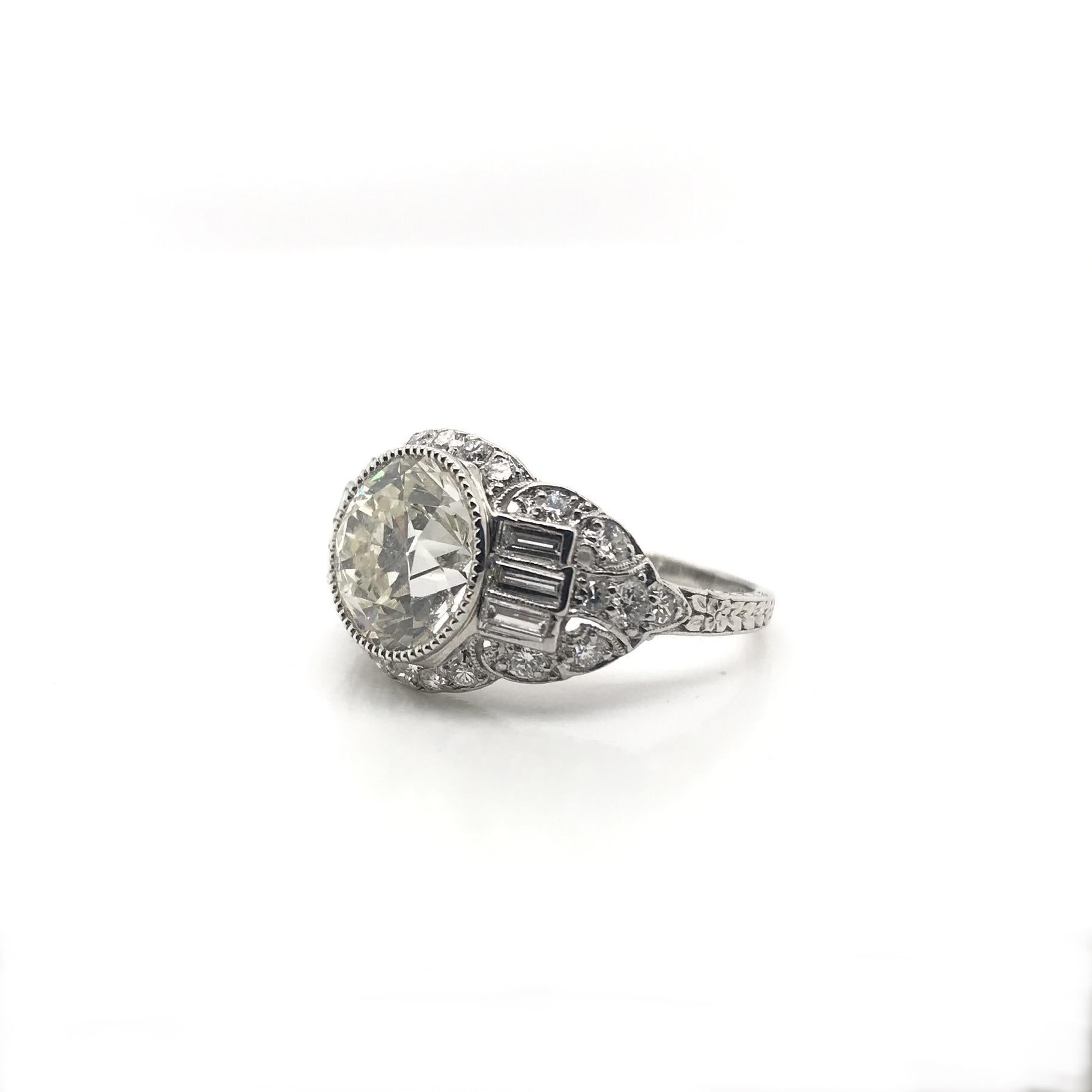 This exceptional antique piece was crafted sometime during the Art Deco design period (1920-1940). The center diamond is an antique Old European cut measuring approximately 3.20 carats. The center diamond grades approximately L in color and VS2 in
