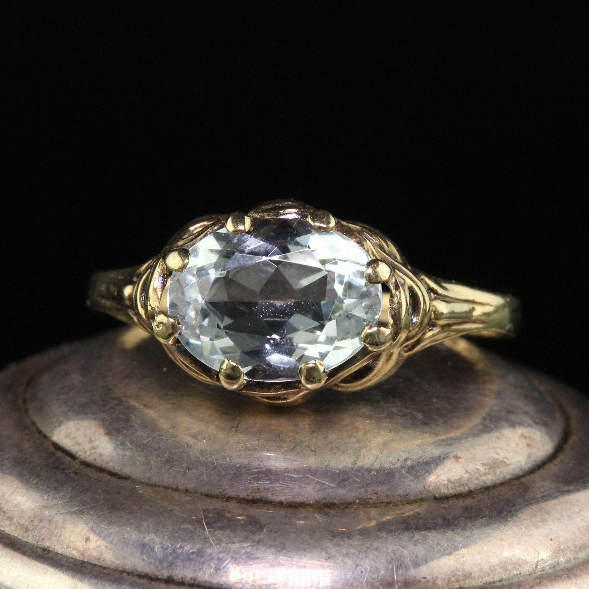 Beautiful Antique Art Deco 8K Yellow Gold Aquamarine Solitaire Vine Design Ring. This beautiful ring is crafted in 8k yellow gold. The center holds a light blue aquamarine that is set in a beautiful Art Deco mounting that has a vine design going