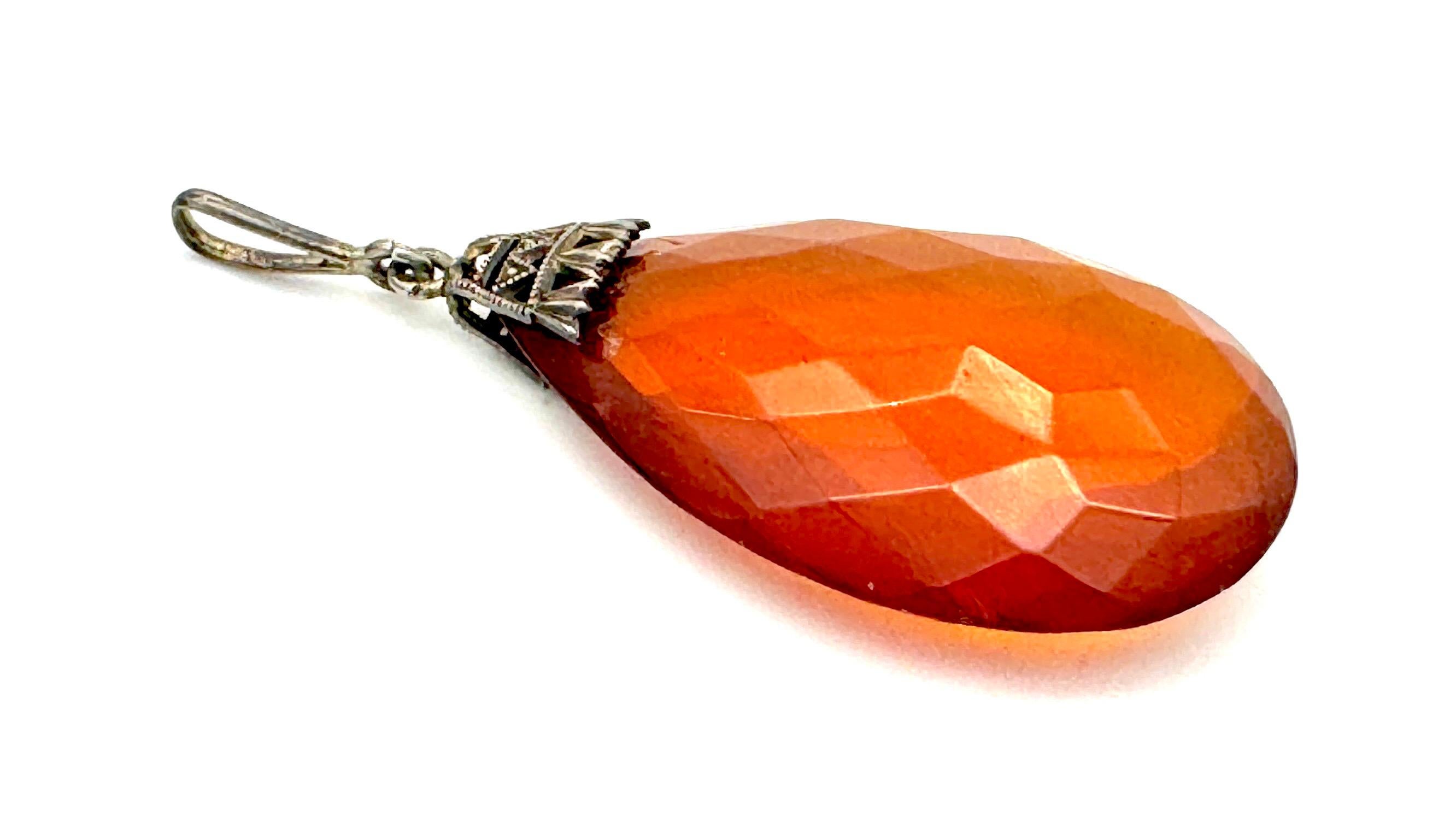 This Art Deco pendant features a large facetted amber drop the colour of dark honey or fine malt whisky. It is mounted in a typical Art Deco silber mount and features the original eyelet. 