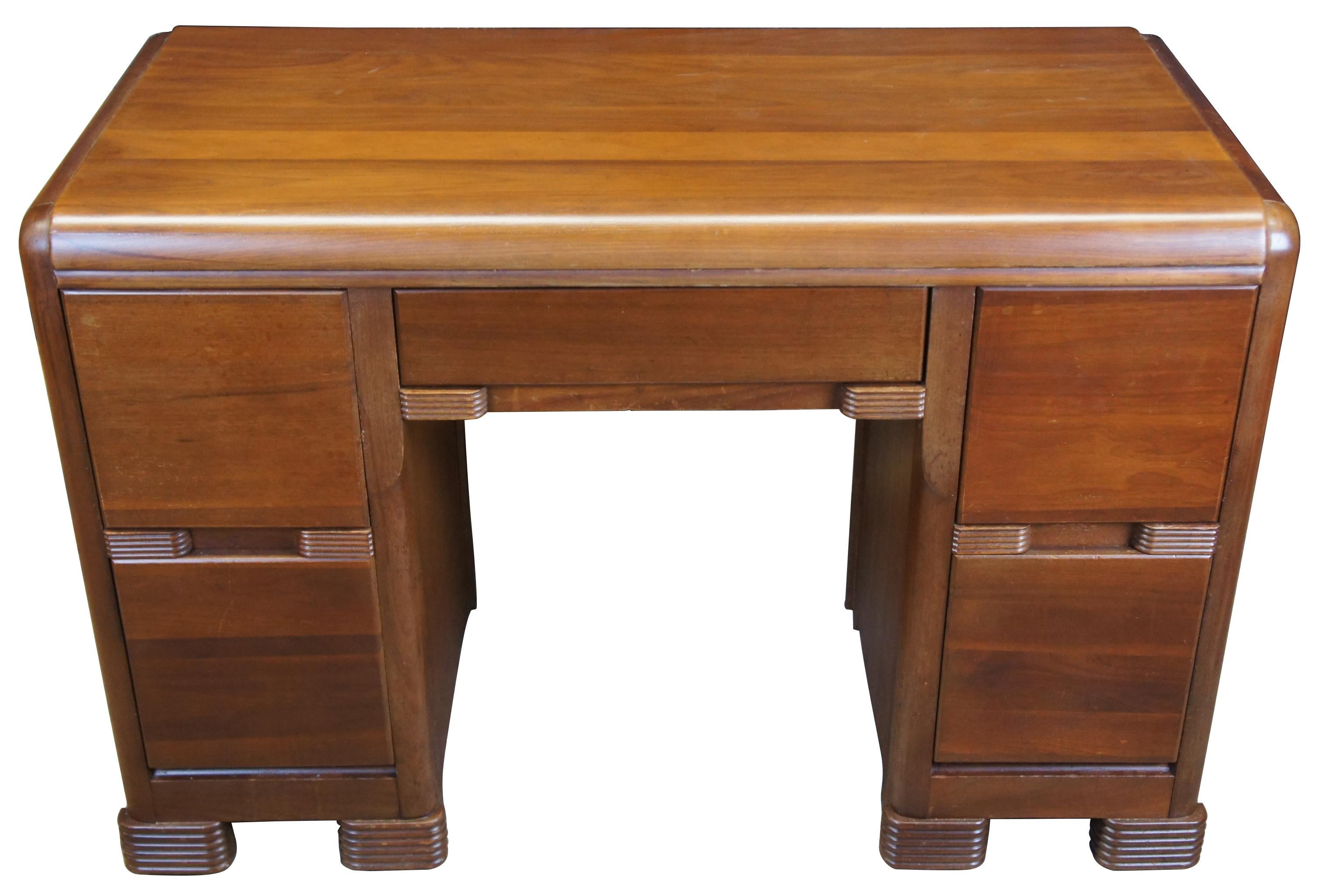 Art Deco era American walnut writing desk. Features the iconic waterfall front with four large drawers flanking a kneehole and upper pencil drawer, circa 1940s.
  