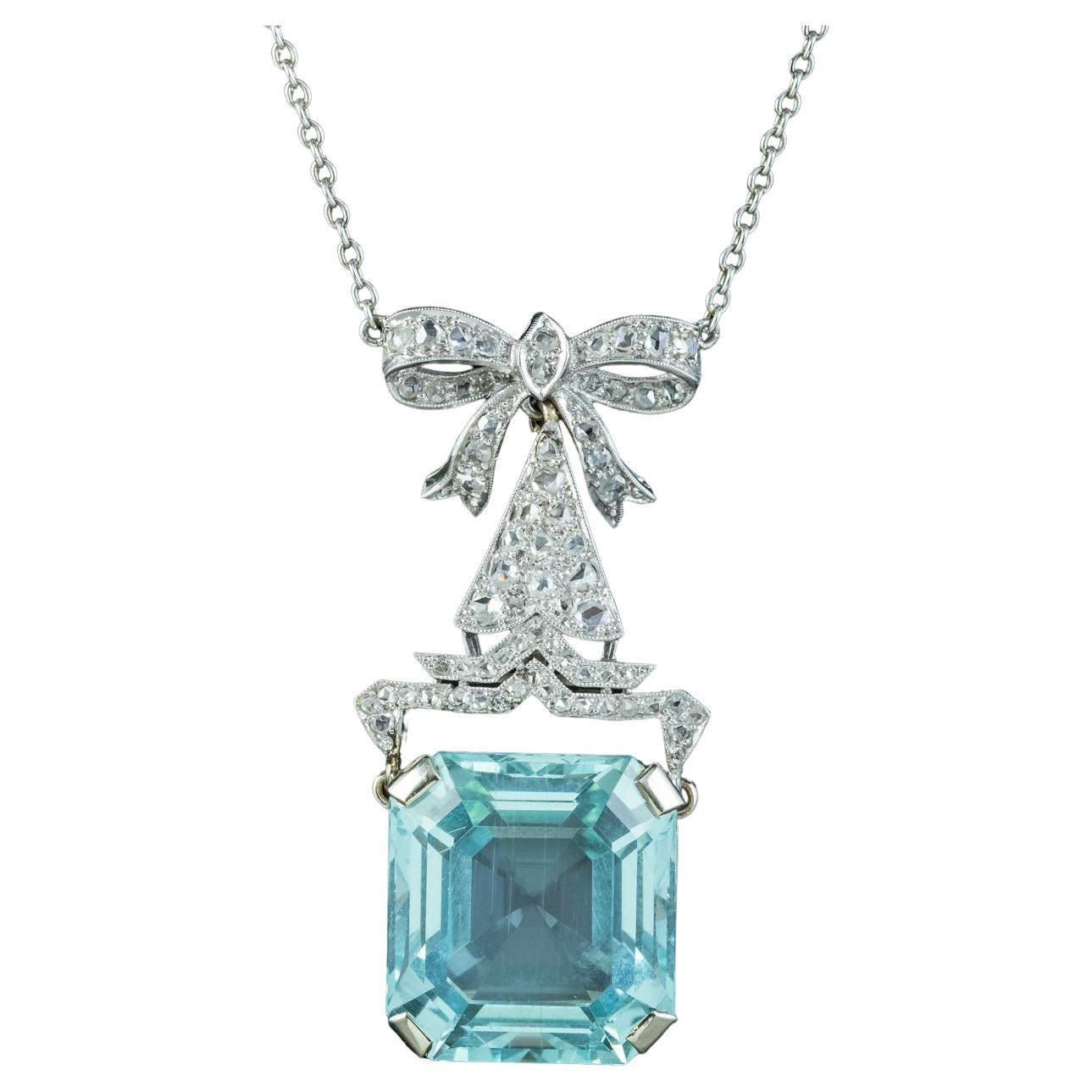 A stunning antique Art Deco lavaliere necklace from the early 1900s boasting a magnificent emerald cut aquamarine at the bottom weighing an impressive 30 carats (approx.) It has a desirable glacier-blue/ green hue and swings freely from a fabulous