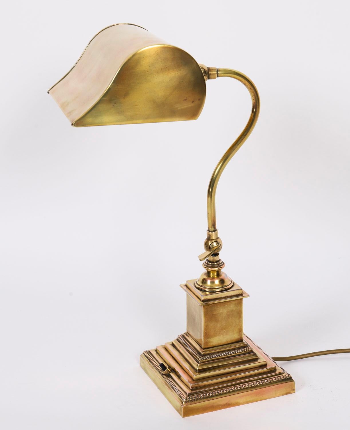 Se trata de una magnífica lámpara antigua Art Decó articulada de latón, datada hacia 1920.

Tiene un vástago ajustable sobre una base de cuello de cisne y se eleva sobre una base decorativa cuadrada escalonada adornada con pedrería y un interruptor