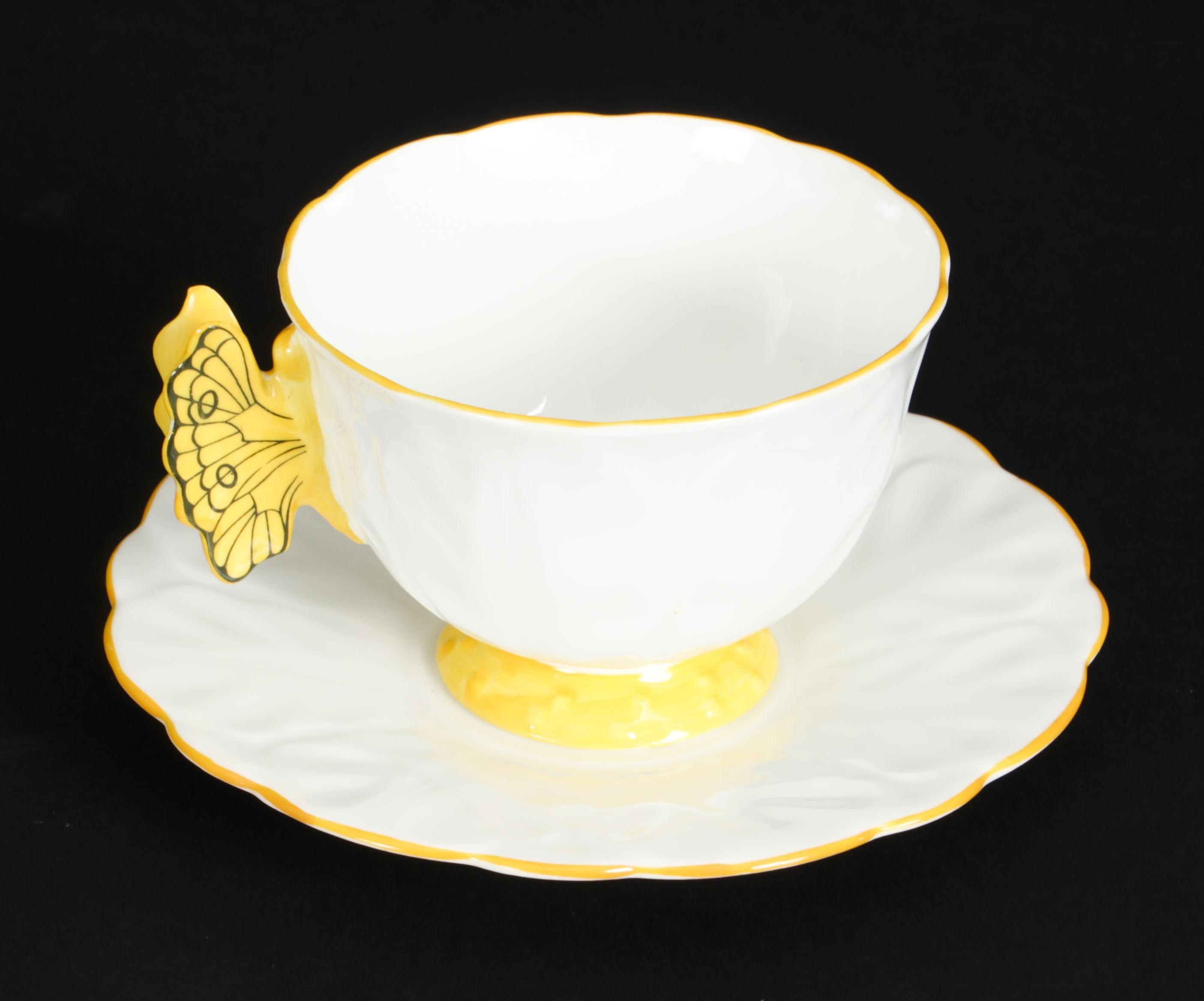 An exquisite, rare, and highly collectable 1920s Art Deco Trio tea cup, saucer and side plate with a bright sunshine yellow trim with a butterfly handle.

Aynsley China was a British producer of fine bone china, tableware and commemorative