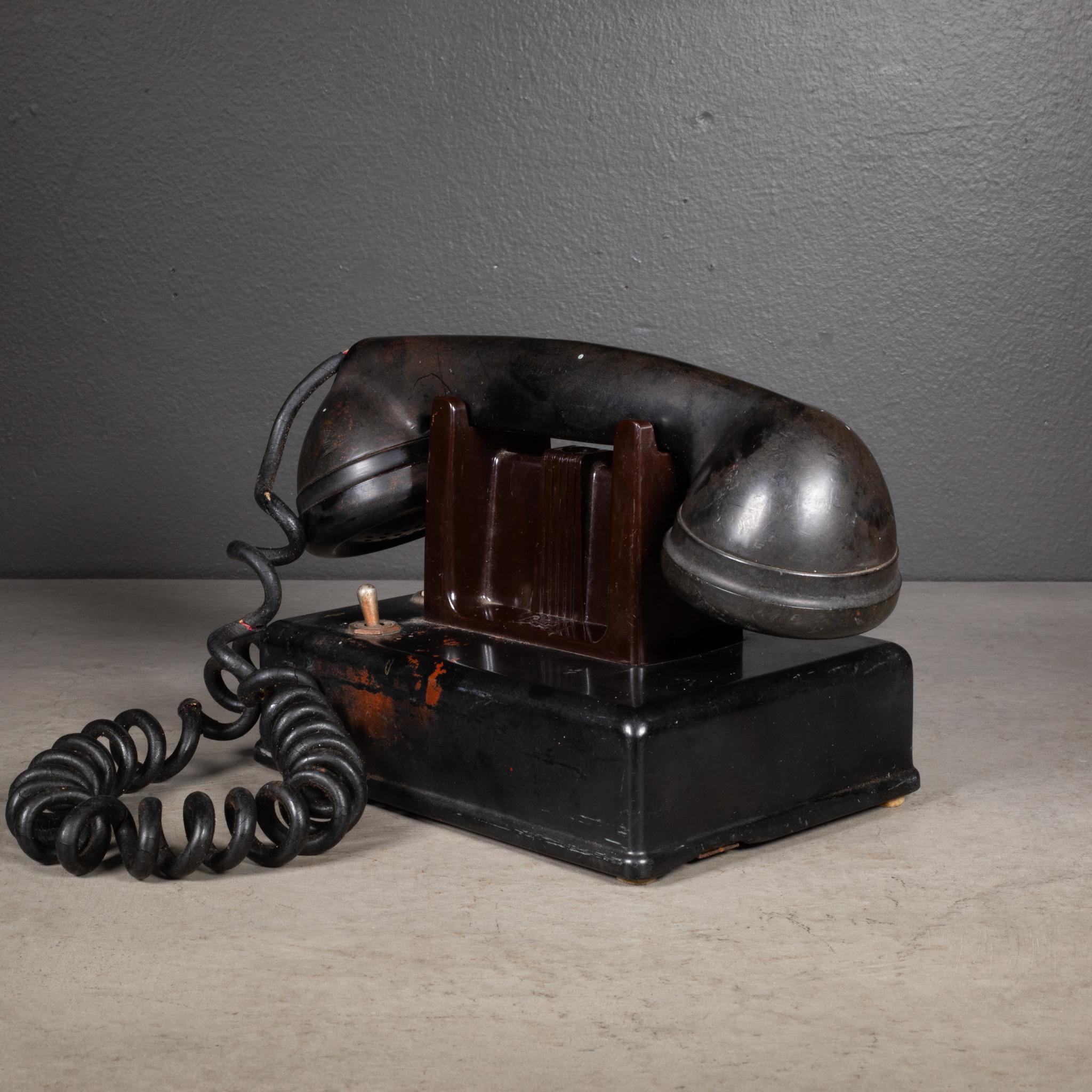 ÜBER

Ein Art-Deco-Hotel-Tischtelefon aus Bakelit mit Druckknopf und Hebel, der nur zum Annehmen und nicht zum Anrufen dient. Beschriftung 