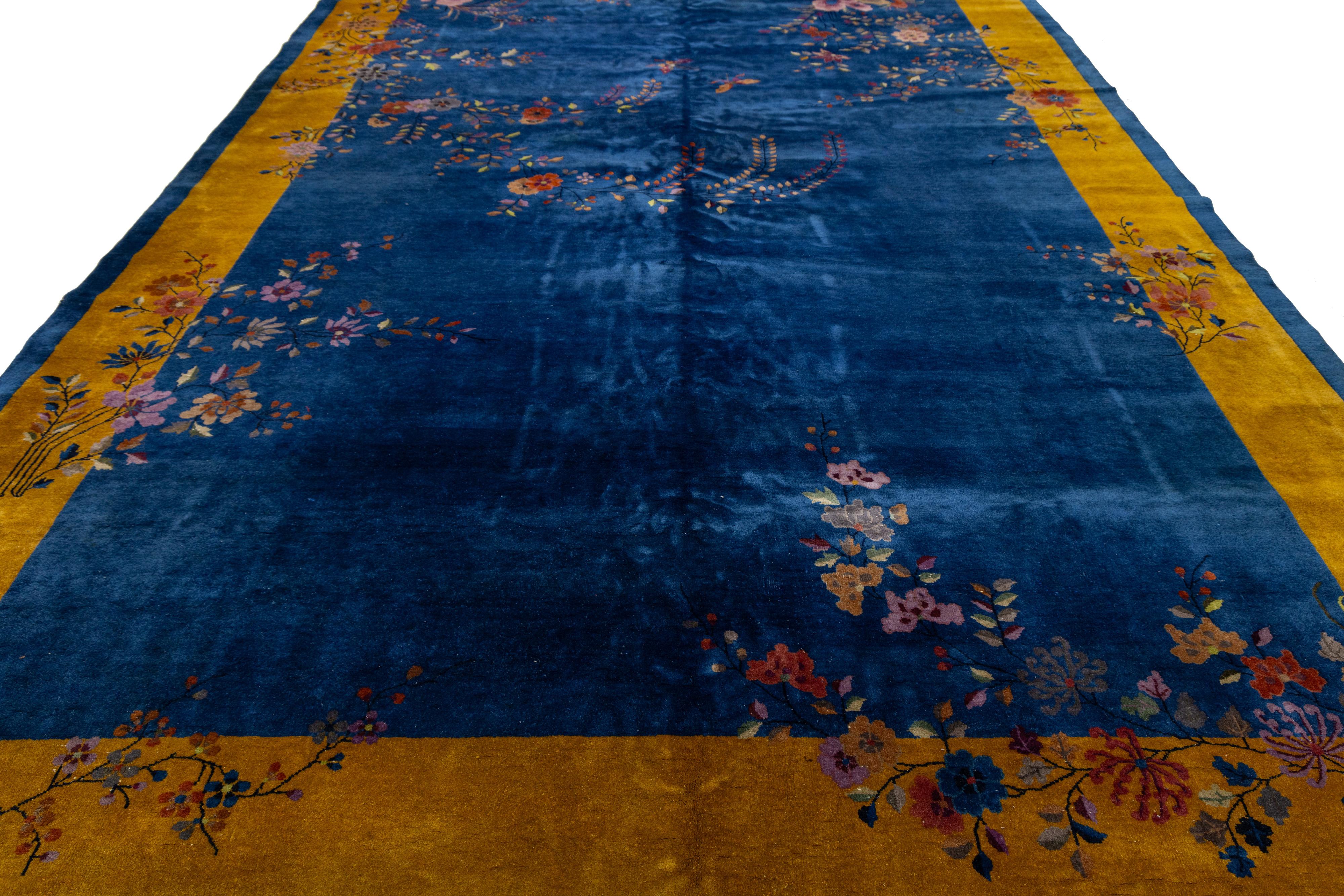 Magnifique tapis chinois antique Art Déco en laine nouée à la main avec un champ bleu. Ce tapis chinois présente un cadre doré, des accents multicolores et un magnifique motif floral chinois sur toute sa surface. 

Ce tapis mesure : 9'11