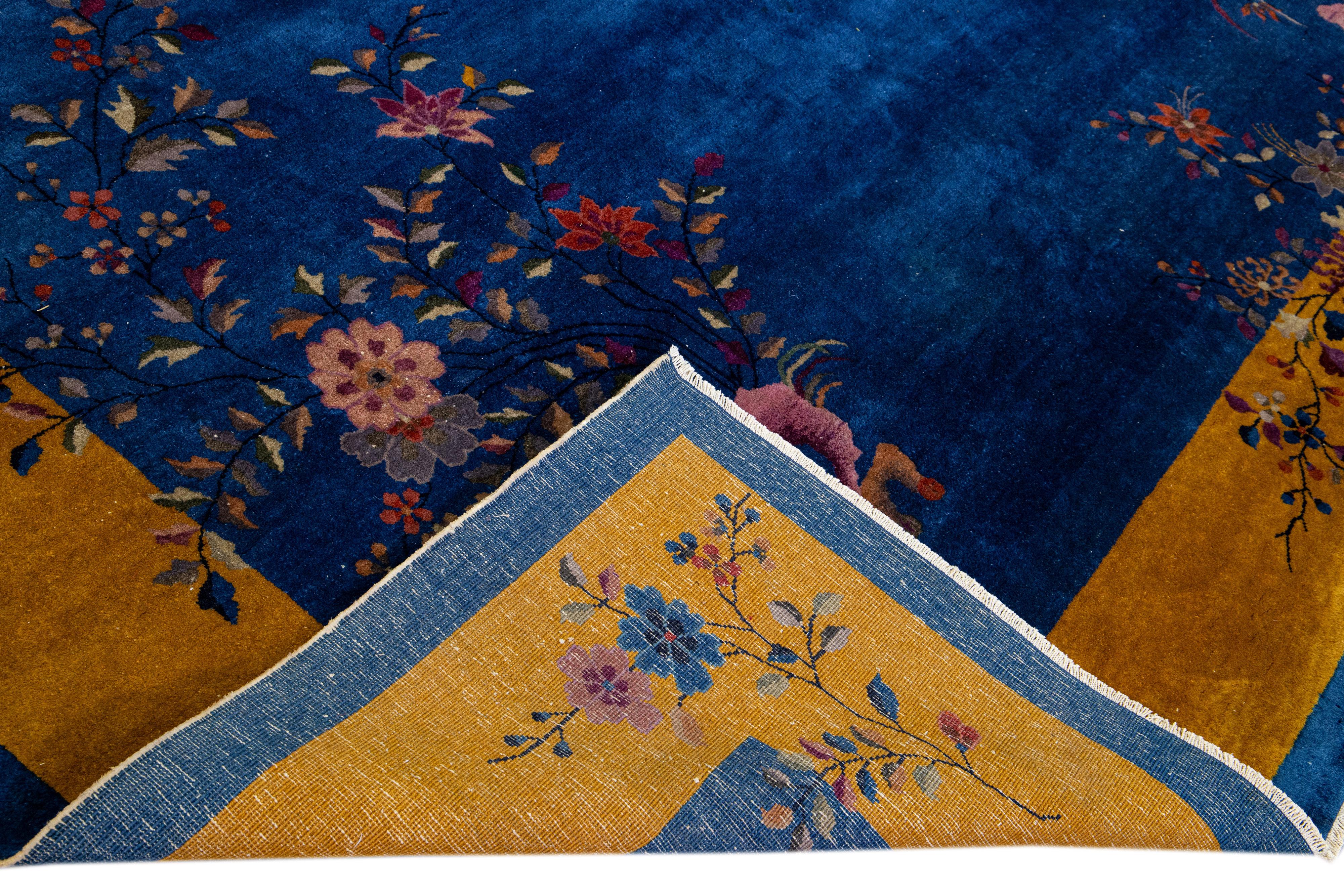 Beautiful antique Art Deco Chinese hand-knotted wool rug with a blue field. This Chinese rug has a goldenrod frame, multi-color accents in a gorgeous all-over Chinese floral design. 

This rug measures: 9'11