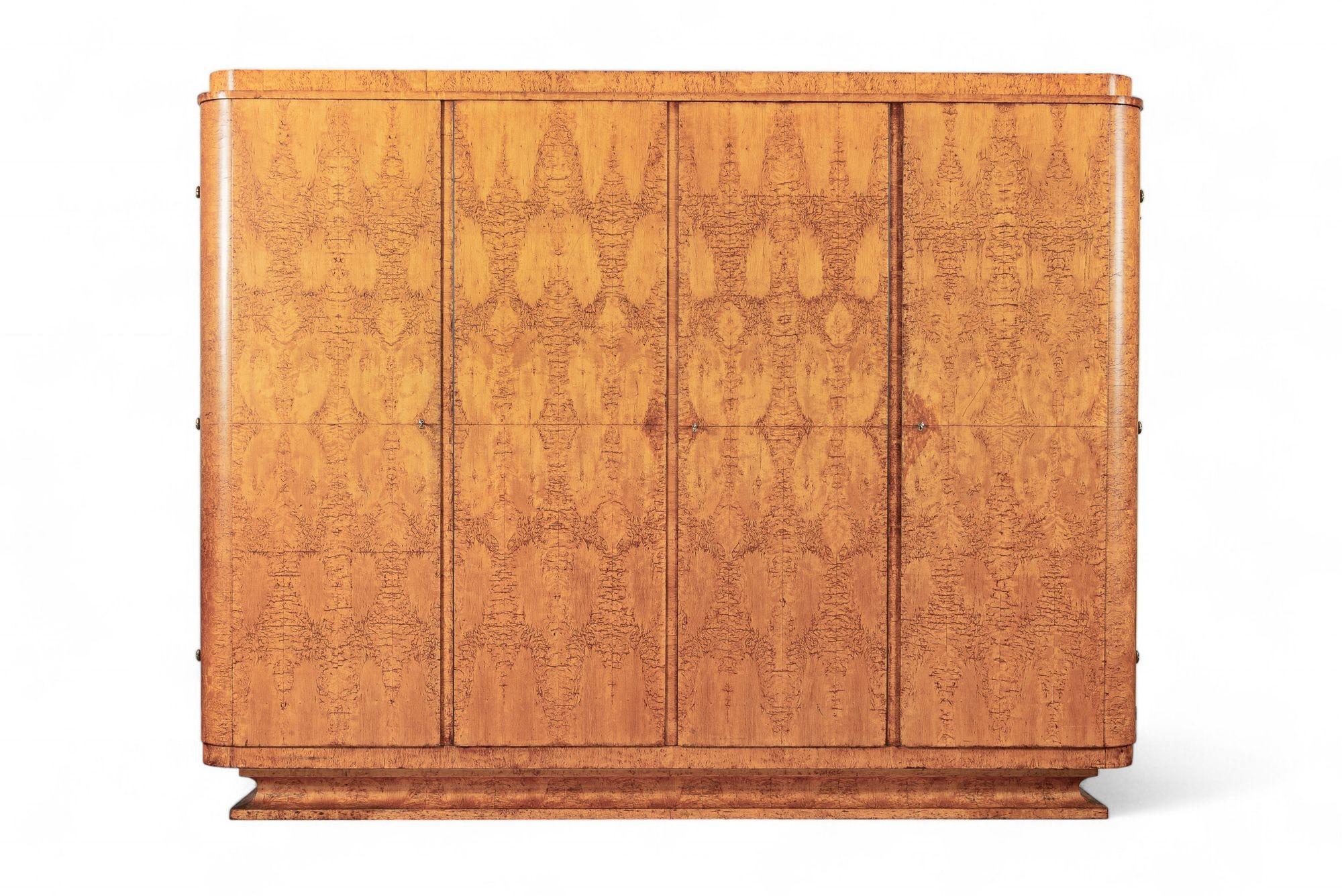 Questo grande armadio o guardaroba in legno Art Deco è del 1940 circa. Il mobile ha un design pulito e geometrico, con curve dolci e dettagli semplici, ed è realizzato a mano con legno di olmo dei Carpazi abbinato al libro e con splendide venature.
