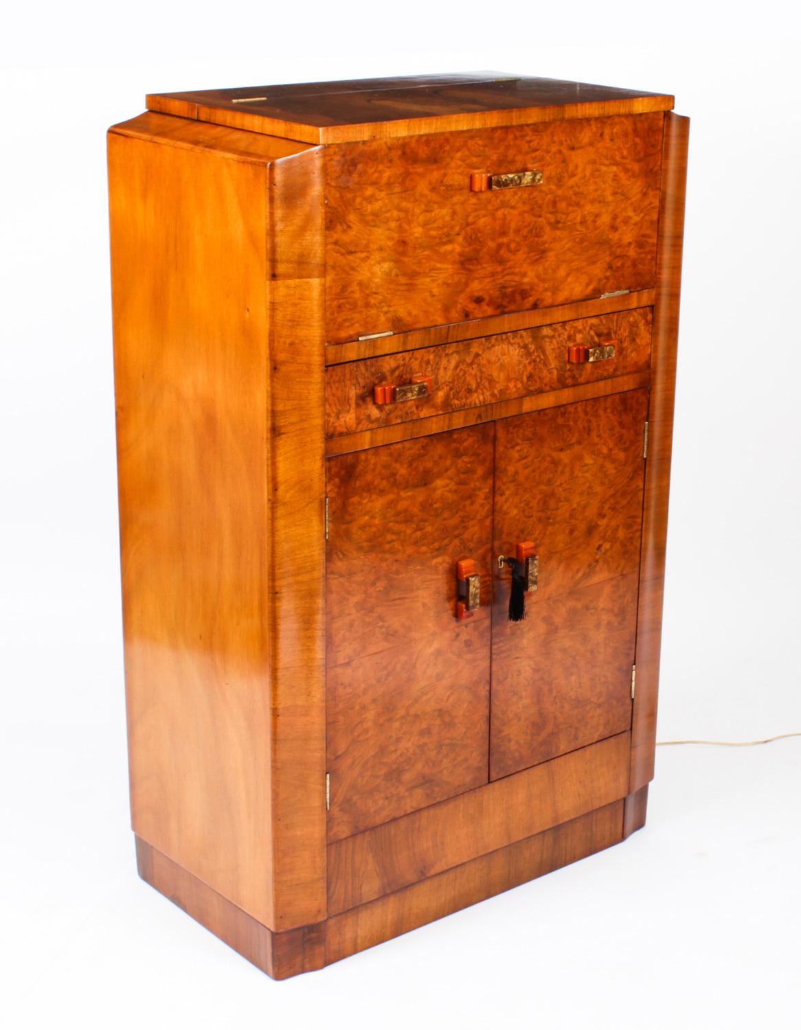 This is a fantastic antique Art Deco burr walnut cocktail cabinet, complete with crystal glassware, circa 1920 in date. 
 
It is of rectangular form, made in beautiful burr walnut, the upper part opens to reveal a fitted mirrored interior with