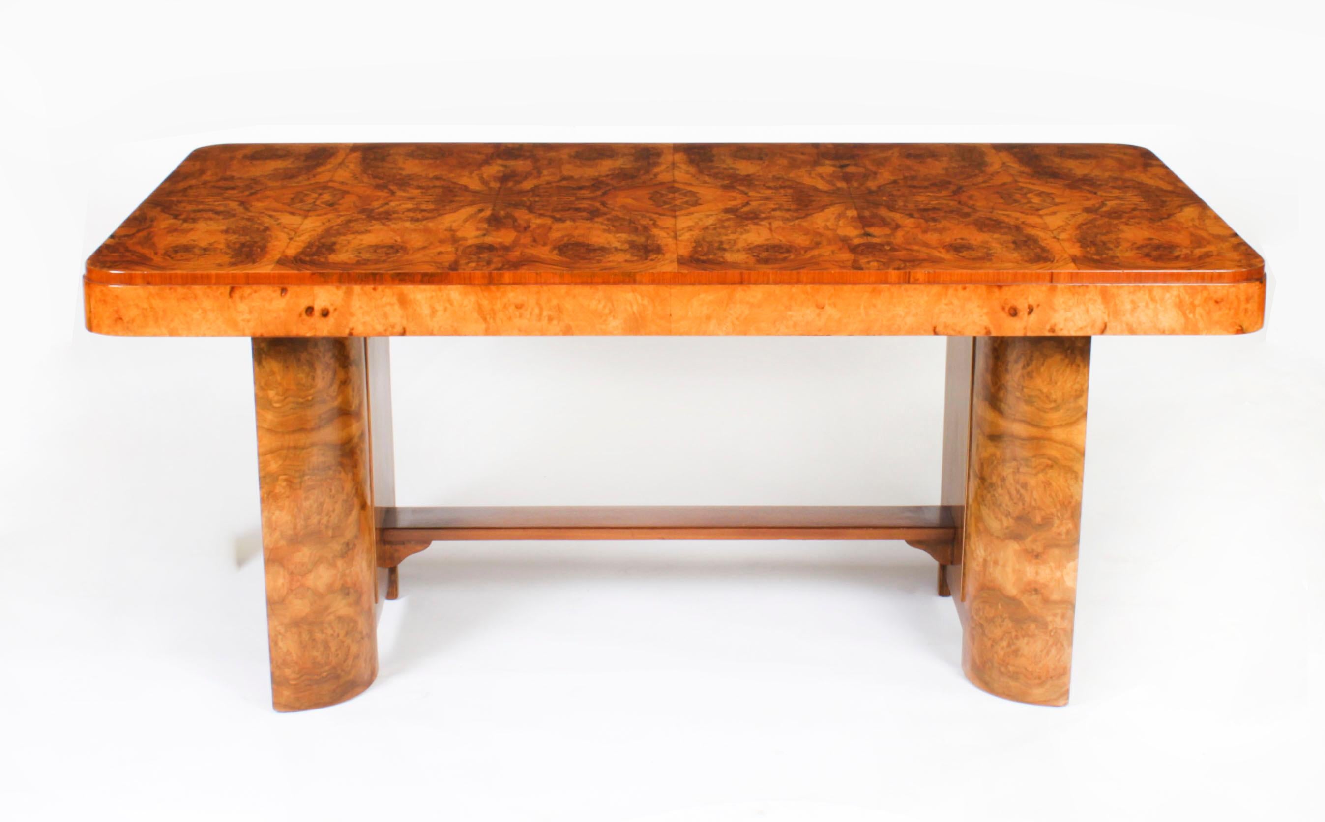 This is an elegant antique burr walnut and crossbanded Art Deco dining table, circa 1920 in date.
The rectangular top with fabulous burr walnut matched veneers and rounded corners.
 
It is raised on attractive twin shaped pedestal supports with