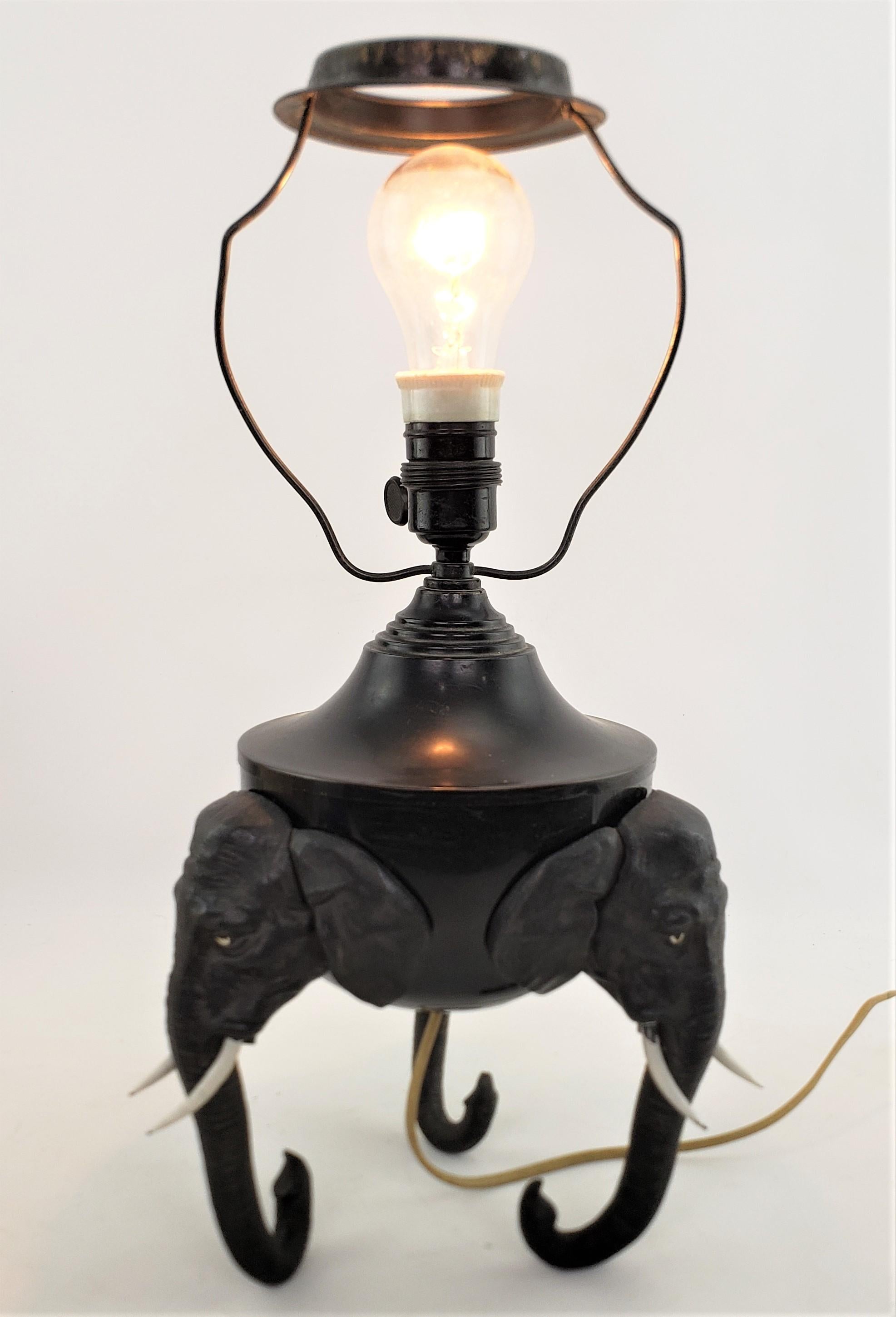 Antike Art-déco-Tischlampe aus gegossenem und patiniertem Zinn mit Elefantenkopf-Füßen (Zink) im Angebot