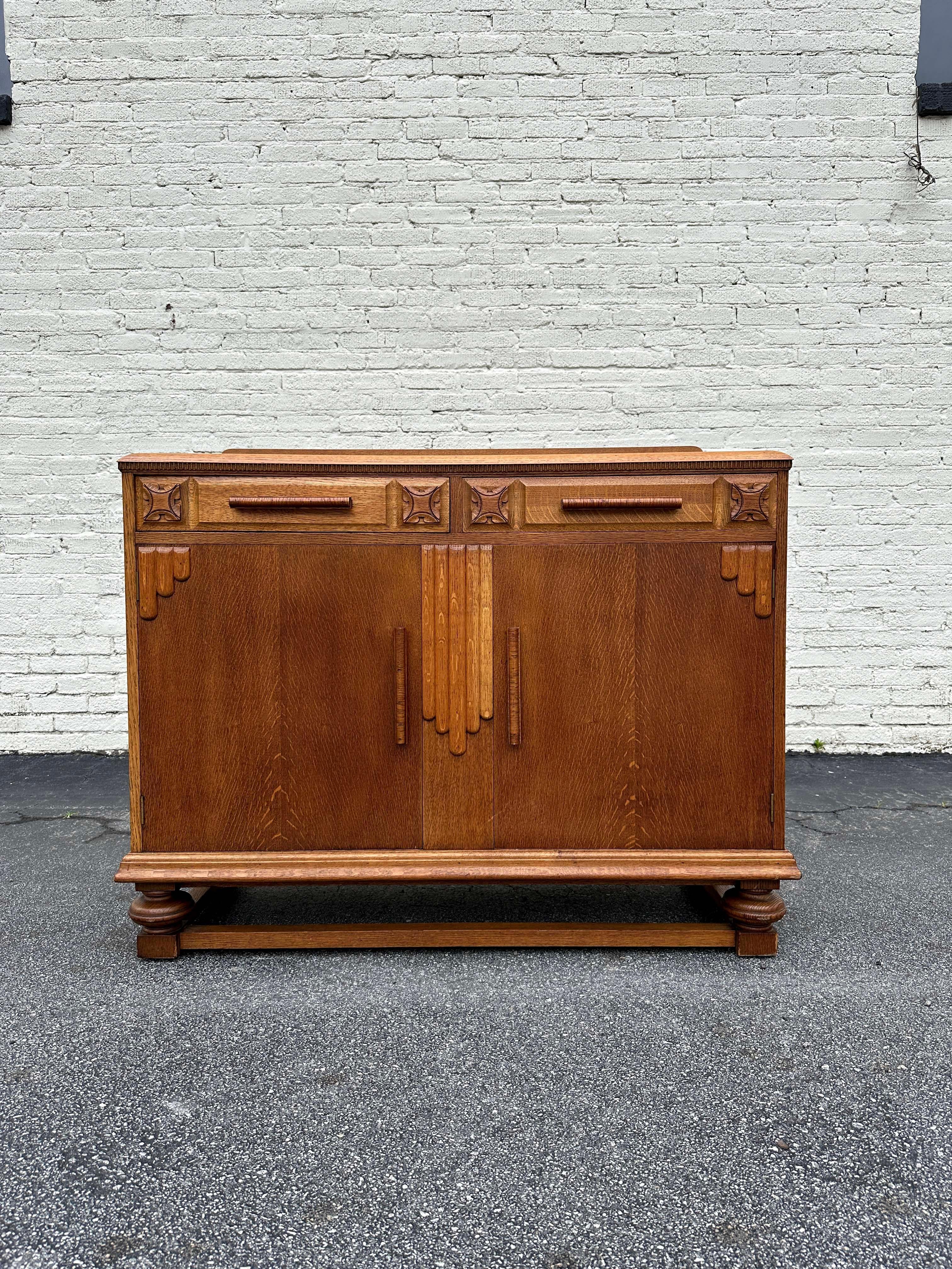 Beautifully carved ornate sideboard buffet from late 1920s, solid oak construction and details on the corners and wood handles. Piece includes 2 drawers.

Some cleaning needed, minor scratches on surface from age and use, but in great