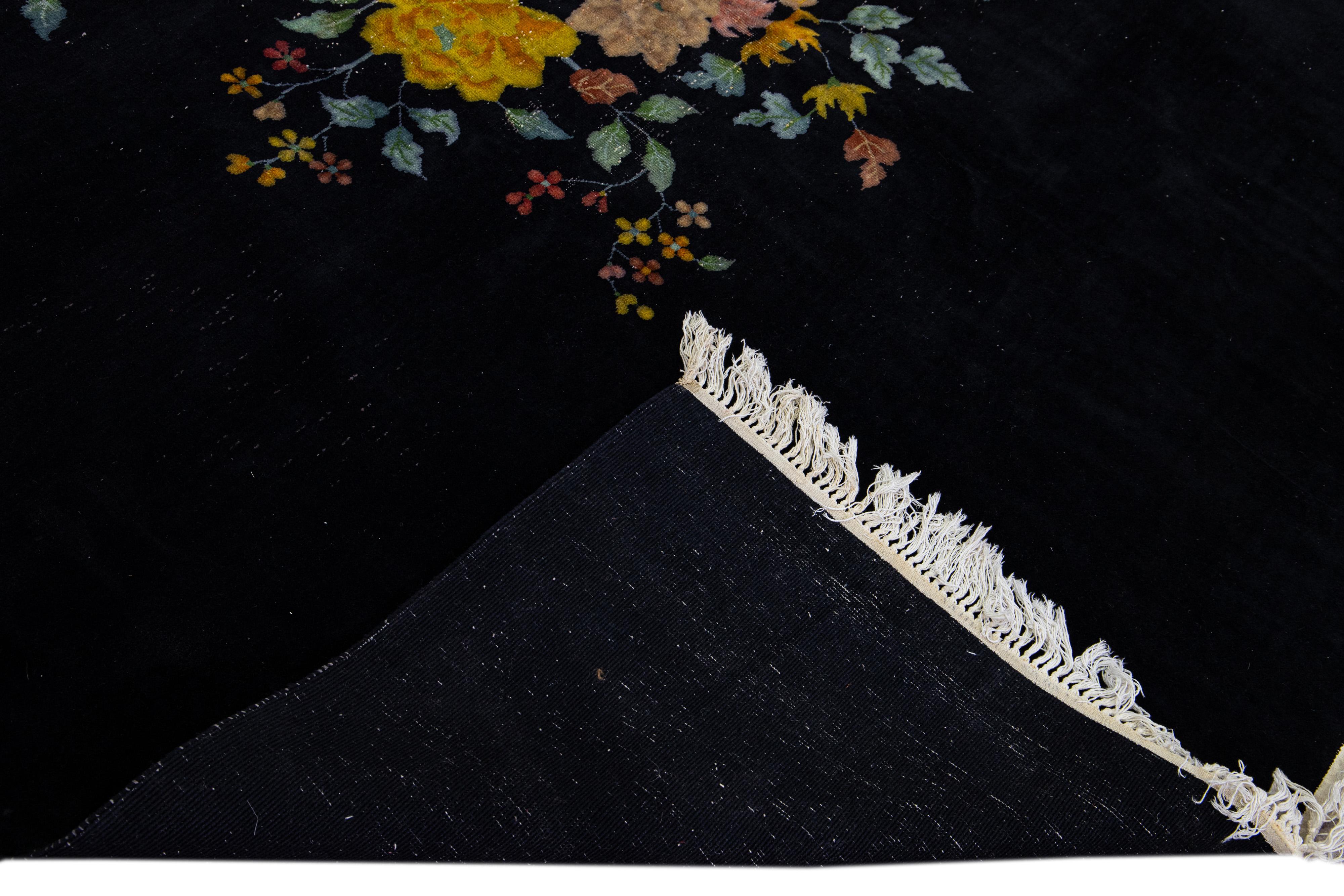 Schöner antiker chinesischer Art-Déco-Teppich aus handgeknüpfter Wolle mit einem dunkelblauen Feld. Dieser chinesische Teppich hat rosa, gelbe, grüne und blaue Akzente in einem prächtigen chinesischen Blumenmuster, das überall zu sehen ist.