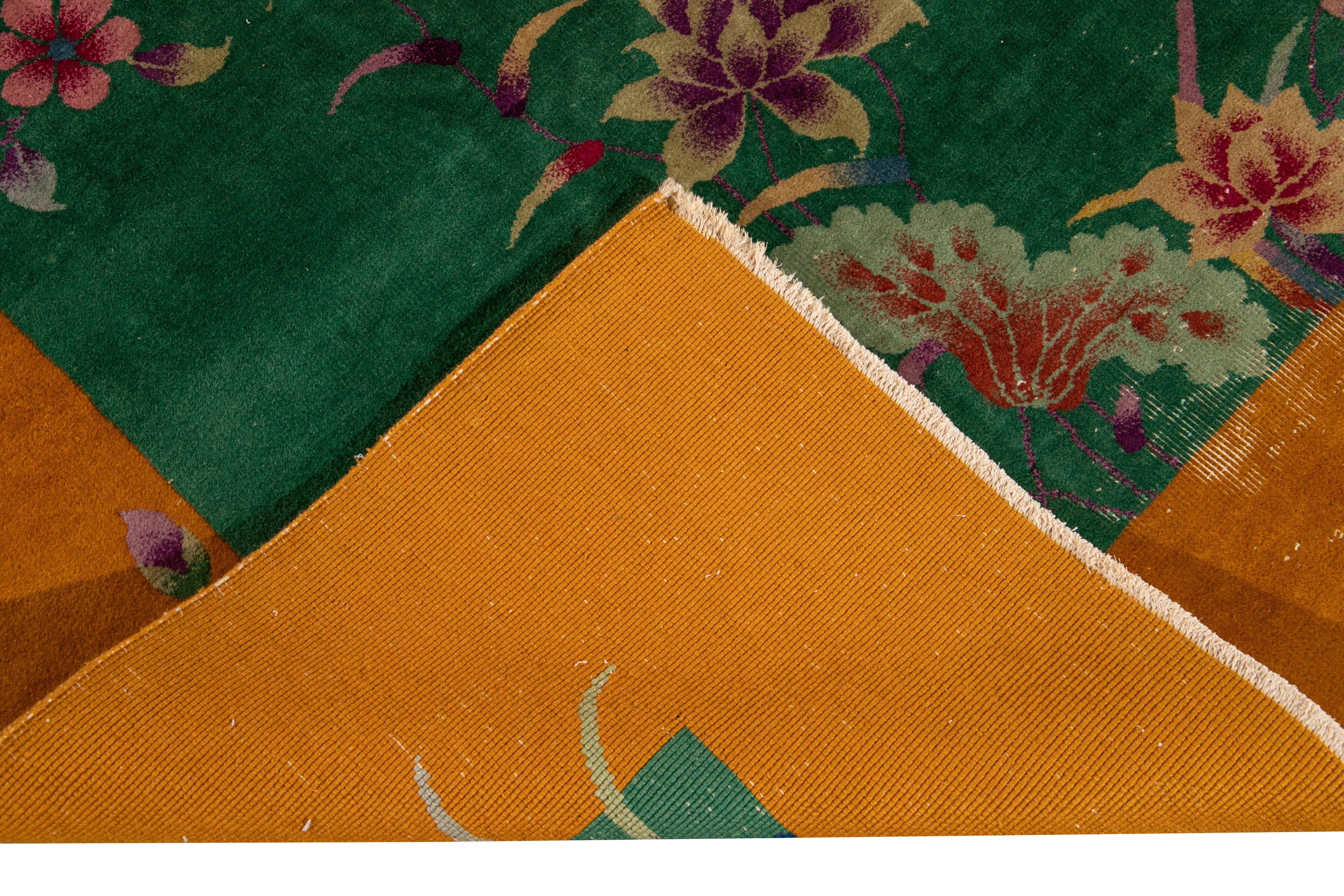 Eine schöne antike Art Deco chinesischen handgeknüpften Wollteppich mit grünem Feld. Dieser Teppich hat einen Rahmen aus Goldrute und mehrfarbigen Akzenten in einem prächtigen chinesischen Blumenmuster. 

Dieser Teppich misst 8'8