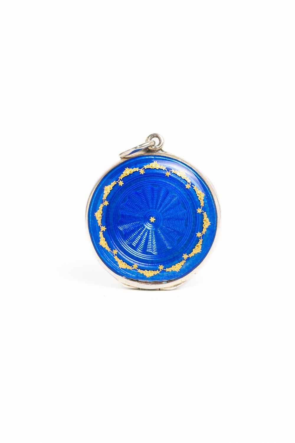 This charming Art Deco 1920's Cobalt Blue and gold guilloche enamel and silver gilt locket is most like made in Austria or Switzerland. The front cover of this beautiful piece is decorated in a striking cobalt blue guilloche enamel with a sunburst