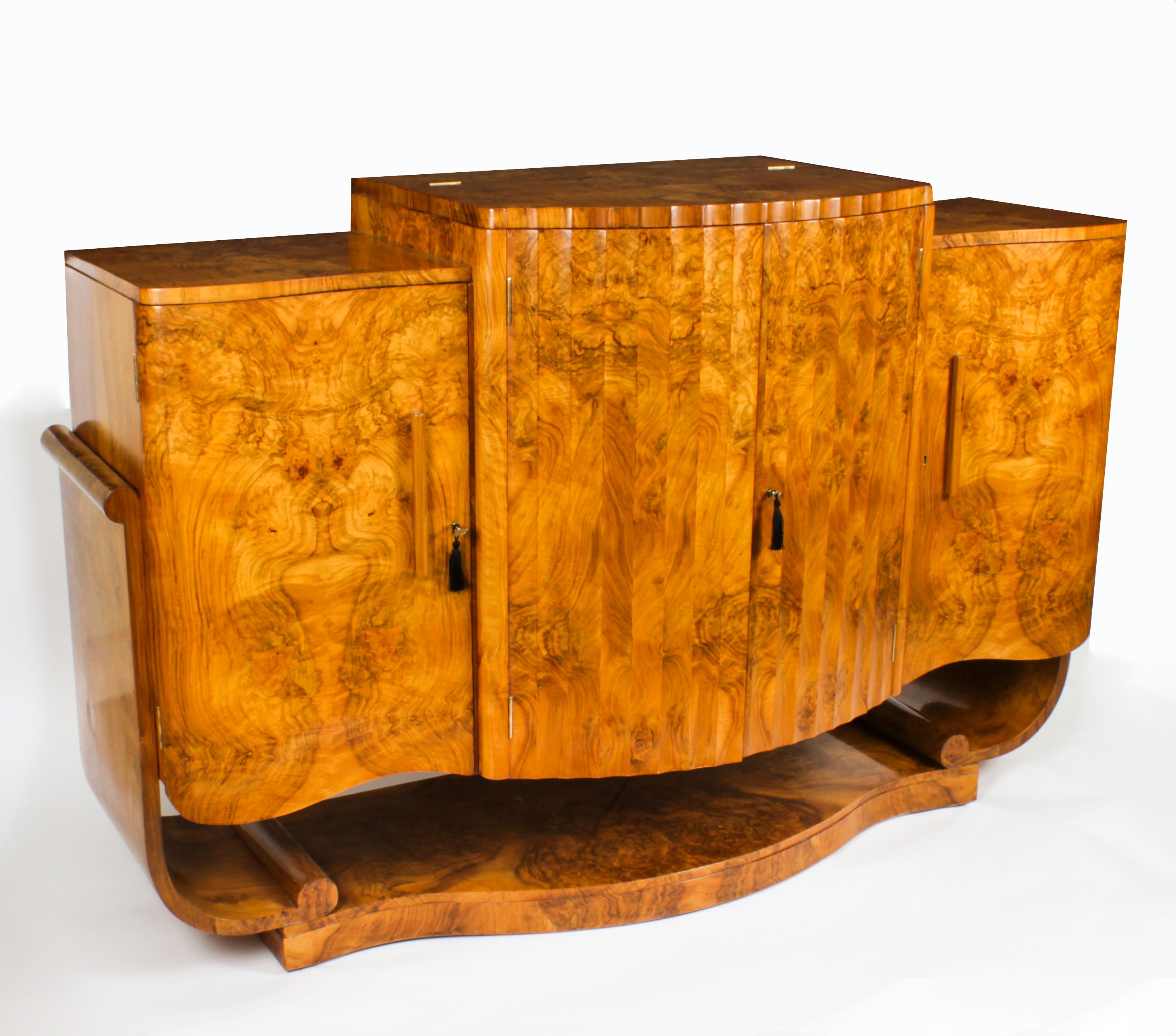This is a superb antique Art Deco Burr Walnut Cocktail Cabinet and Sideboard attributed to Harry and Lou Epstein complete with crystal glassware, C1920 in date.
 
The cabinet has wonderful burr walnut veneers and features a shaped form with a