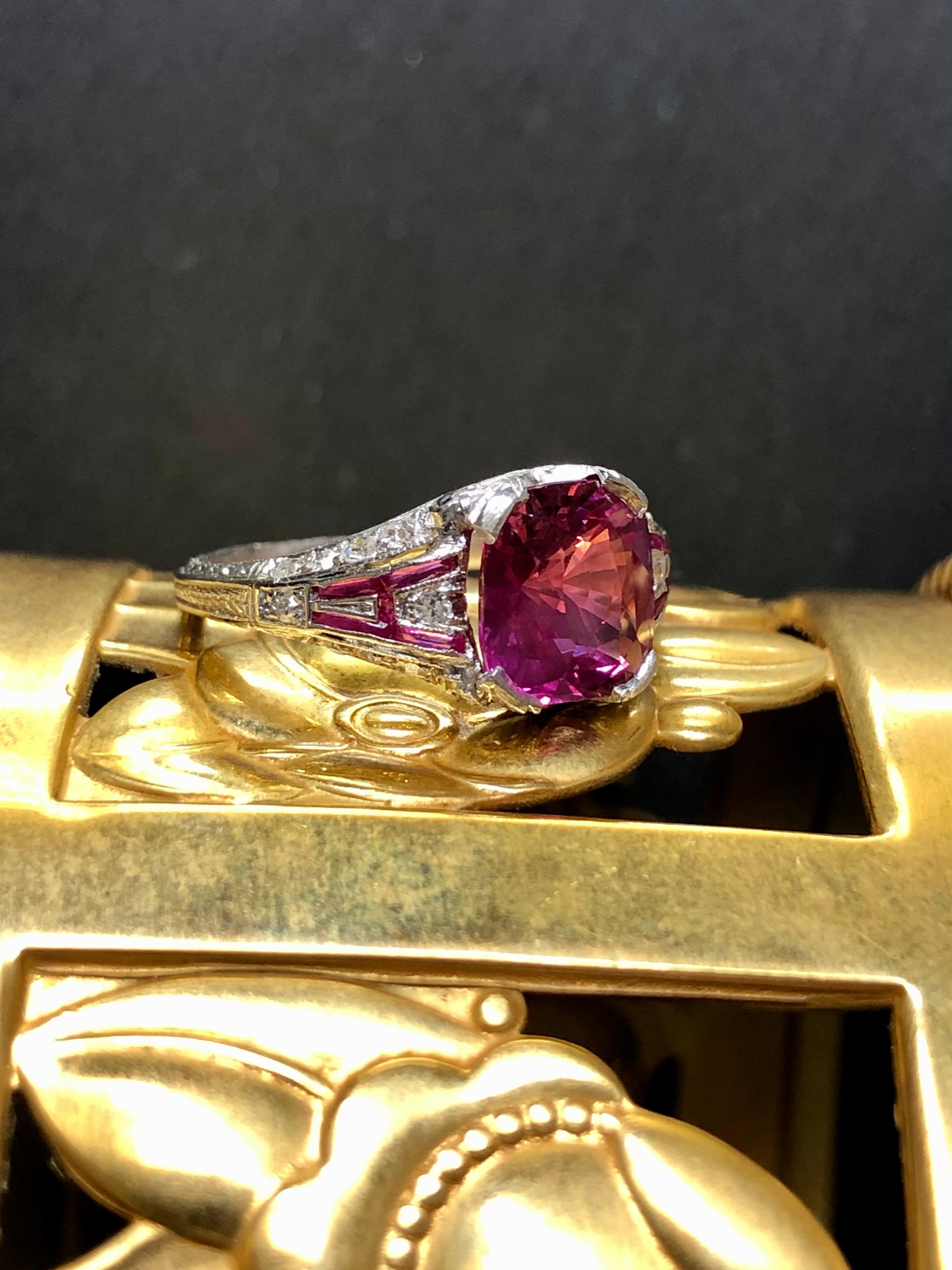 An absolutely stunning ring and unlike anything we have ever owned. The center stone is a 2.53ct NO HEAT pink sapphire exhibiting exceptional color and is 100% eye clean only showing needles when you rock the stone under magnification. That may be