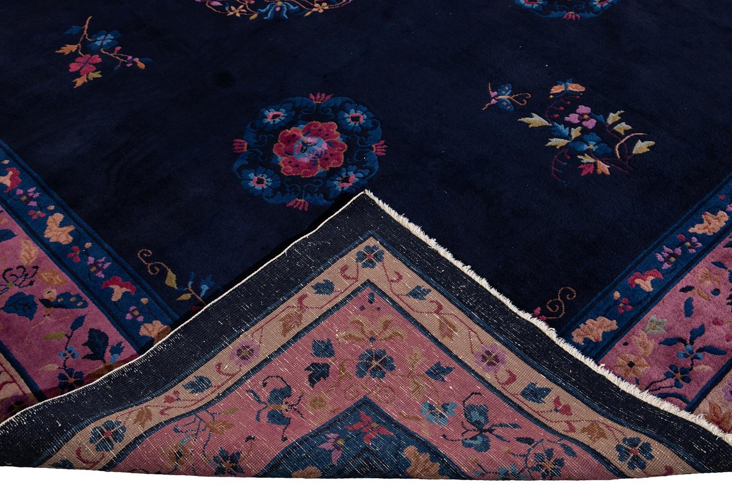 Beautiful antique Chinese Art Deco rug, hand knotted wool with a dark blue field, purple frame in an all-over Classic Chinese floral design, circa 1920.

This rug measures: 9' x 11'10
