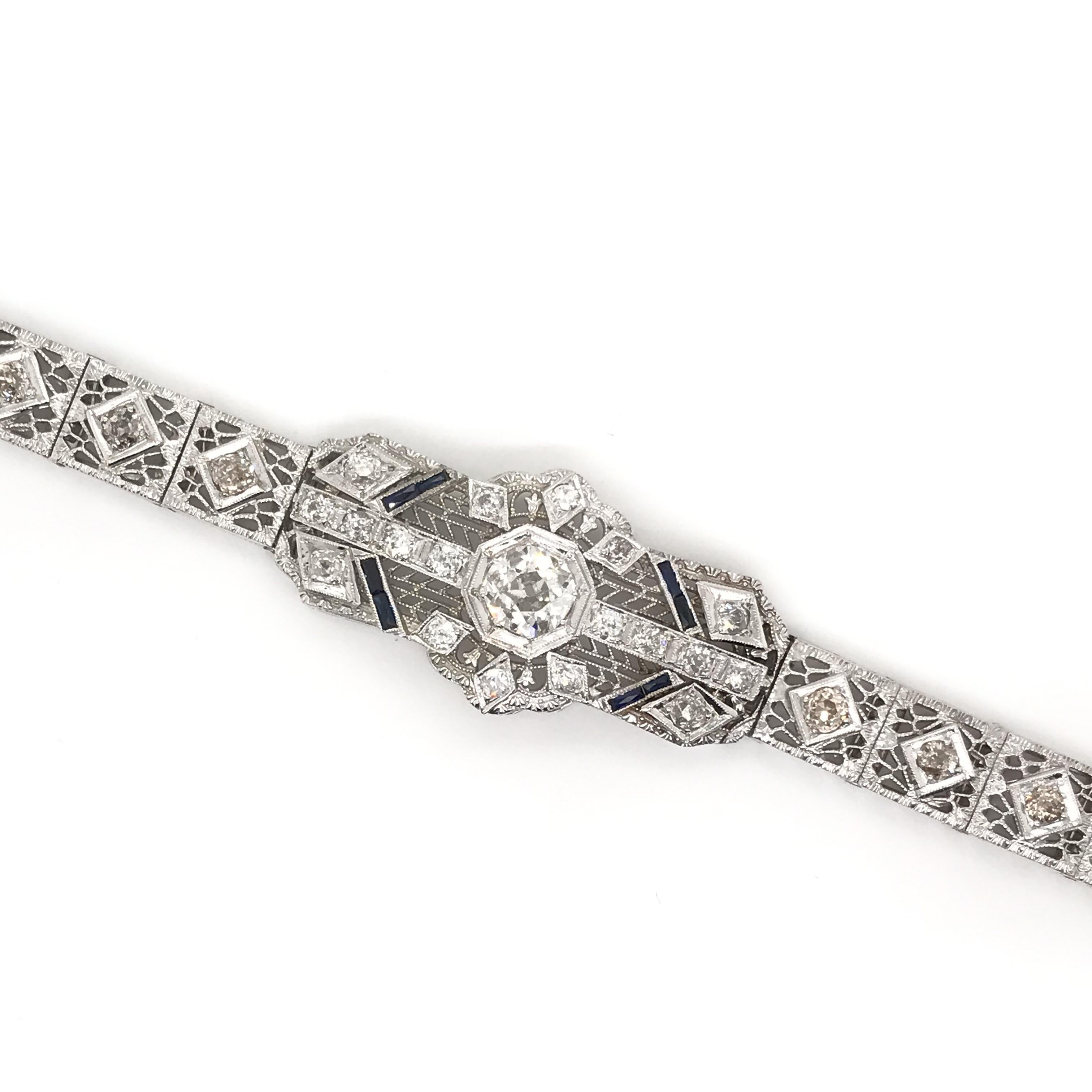This exquisite antique piece was crafted sometime during the Art Deco design period (1920-1940). This phenomenal antique filigree bracelet features 27 diamonds including a center diamond measuring approximately 1 carat. The diamonds are antique Old