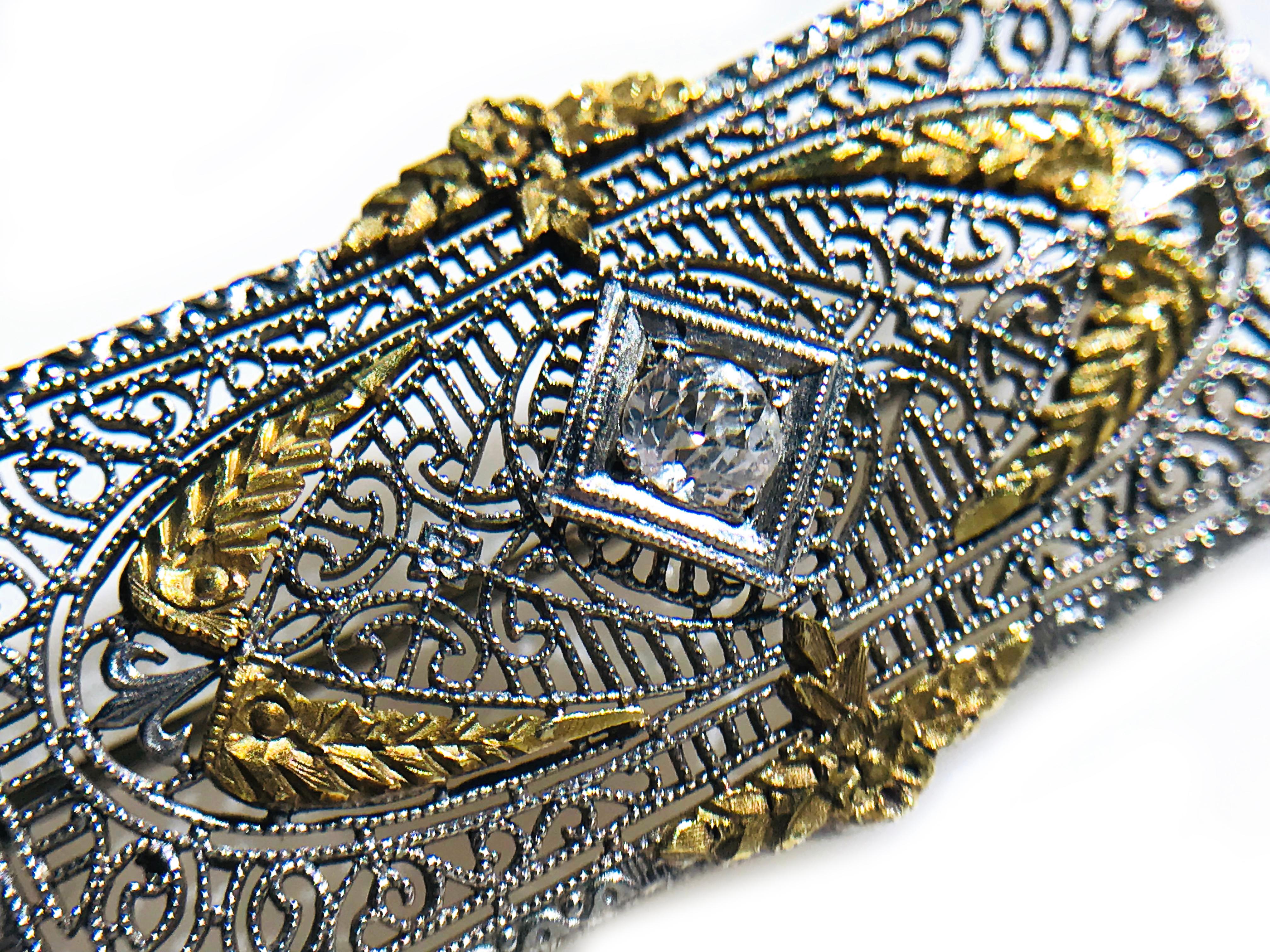 Stunning Antique Art Deco platinum and 14k white gold brooch with an intricate filigree design that is as elegant as lace and provides the perfect setting for the featured old European-cut 3.4mm diamond. Diamond has an approximate weight of 0.15