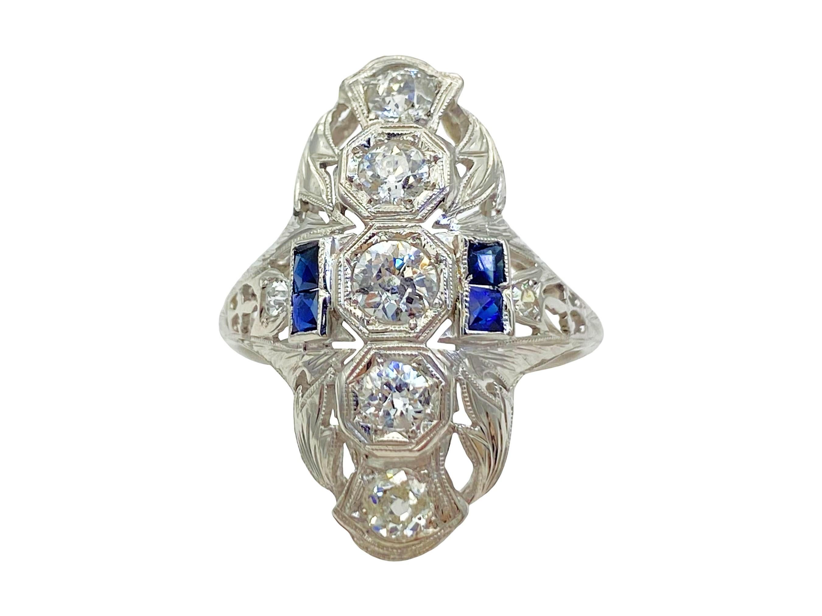 This is a fine antique Art Deco diamond and natural sapphire ring circa the 1920s. This stunning ring is comprised of 7 diamonds and 4 natural blue sapphires. Five old European cut diamonds are prong-set in octagonal settings down the length of the