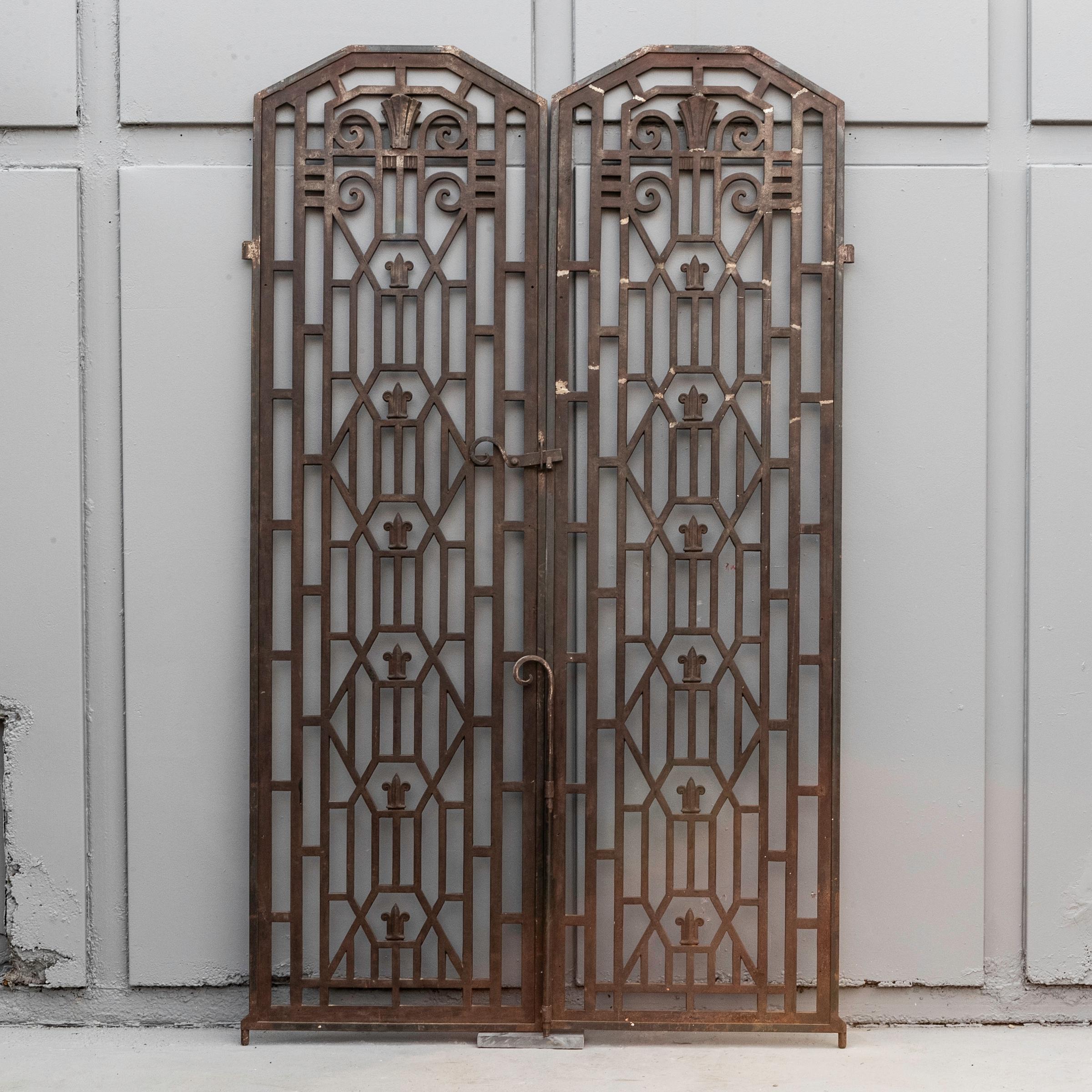 Distinctively Art Deco, these antique gates provide a feature entranceway.

The wrought iron pair are lavishly decorated with geometric form typical of the Art Deco movement. They are currently set to install on a pin hinge. The gates would make an
