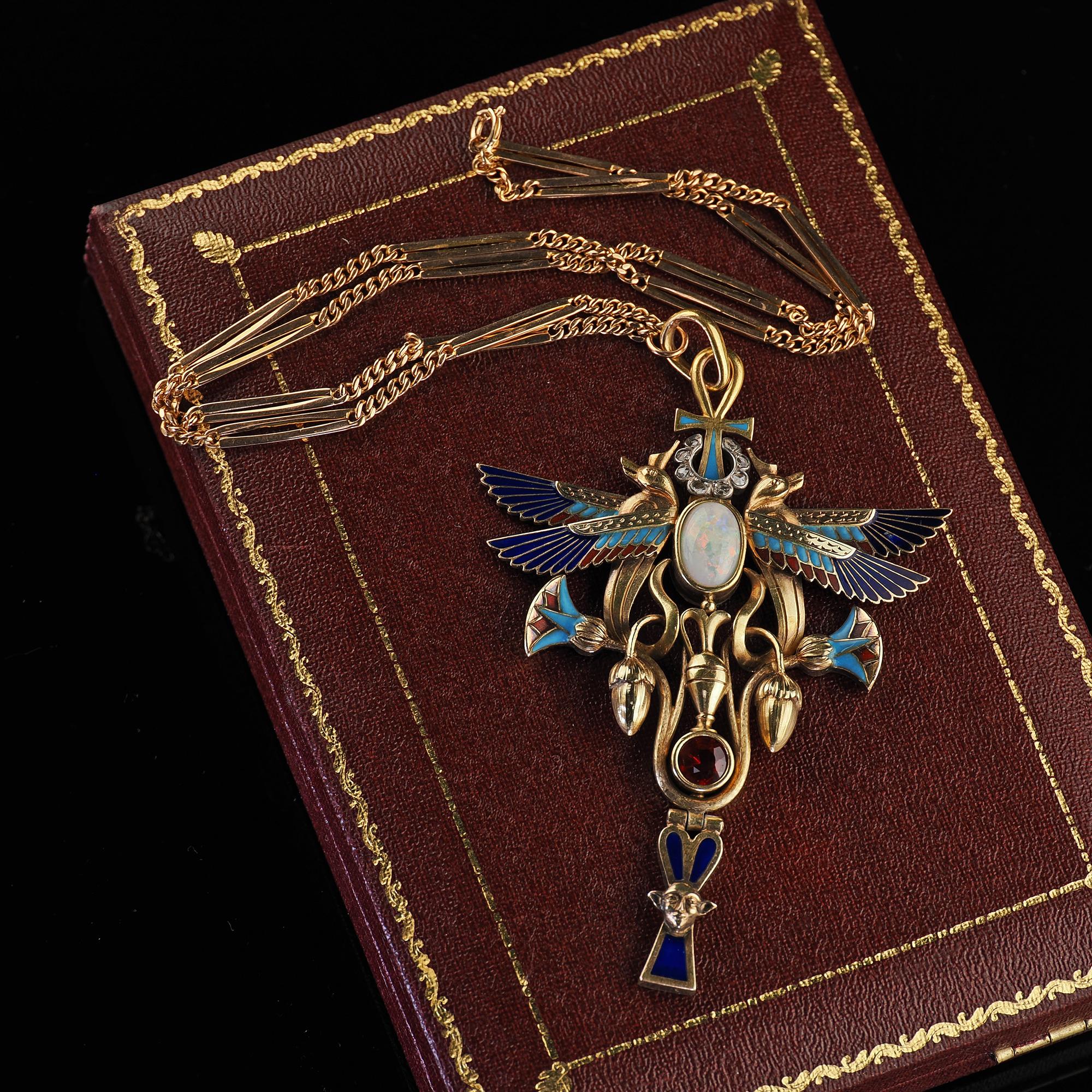 Beautiful Antique Art Deco Egyptian Revival 18K Yellow Gold Opal Diamond Garnet Pendant. This incredible Art Deco Egyptian Revival opal, diamond and garnet pendant is crafted in 18k yellow gold with an 18k rose gold chain. The necklace features a