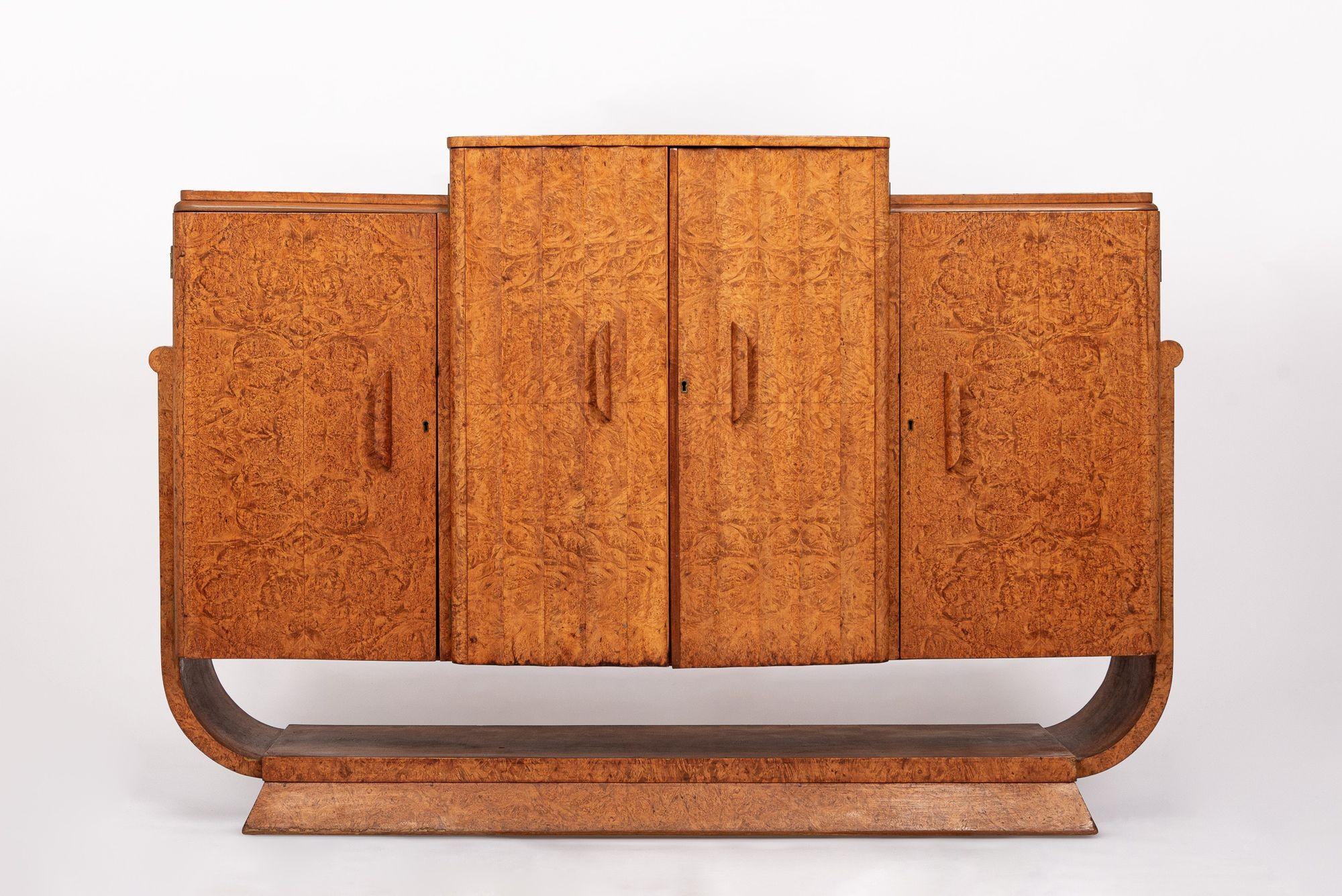 Este excepcional mueble bar o aparador inglés Art Decó de madera de olmo es de hacia 1930. El mueble está fabricado a mano por expertos y presenta unas impresionantes vetas de madera de olmo de los Cárpatos con un diseño de 