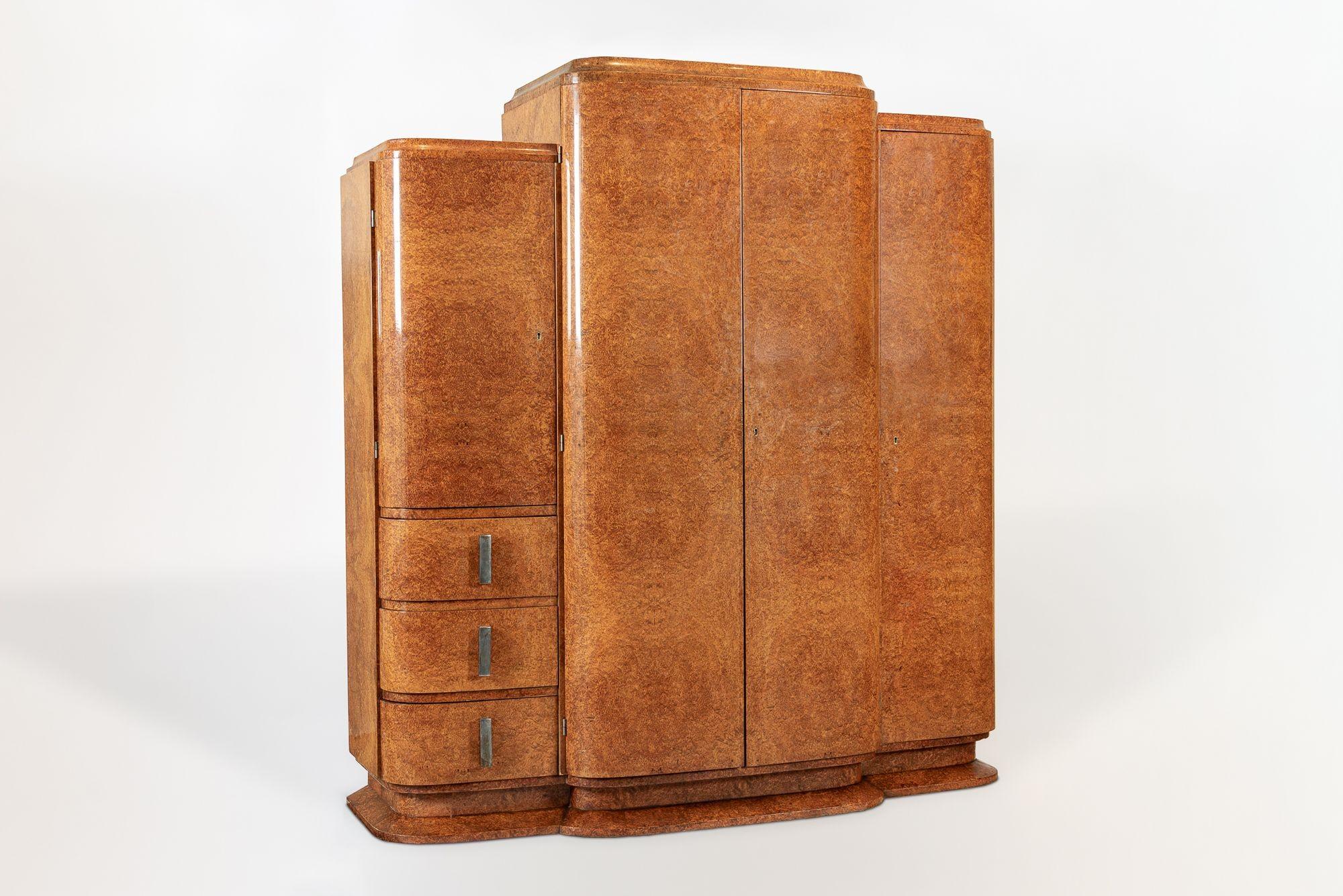 Cette exceptionnelle armoire-vestiaire ancienne en bois laqué Art Déco date d'environ 1940. Il est impeccablement fabriqué à la main en bois massif et en placage d'orme des Carpates, avec de superbes veinures assorties. Ce meuble unique présente de
