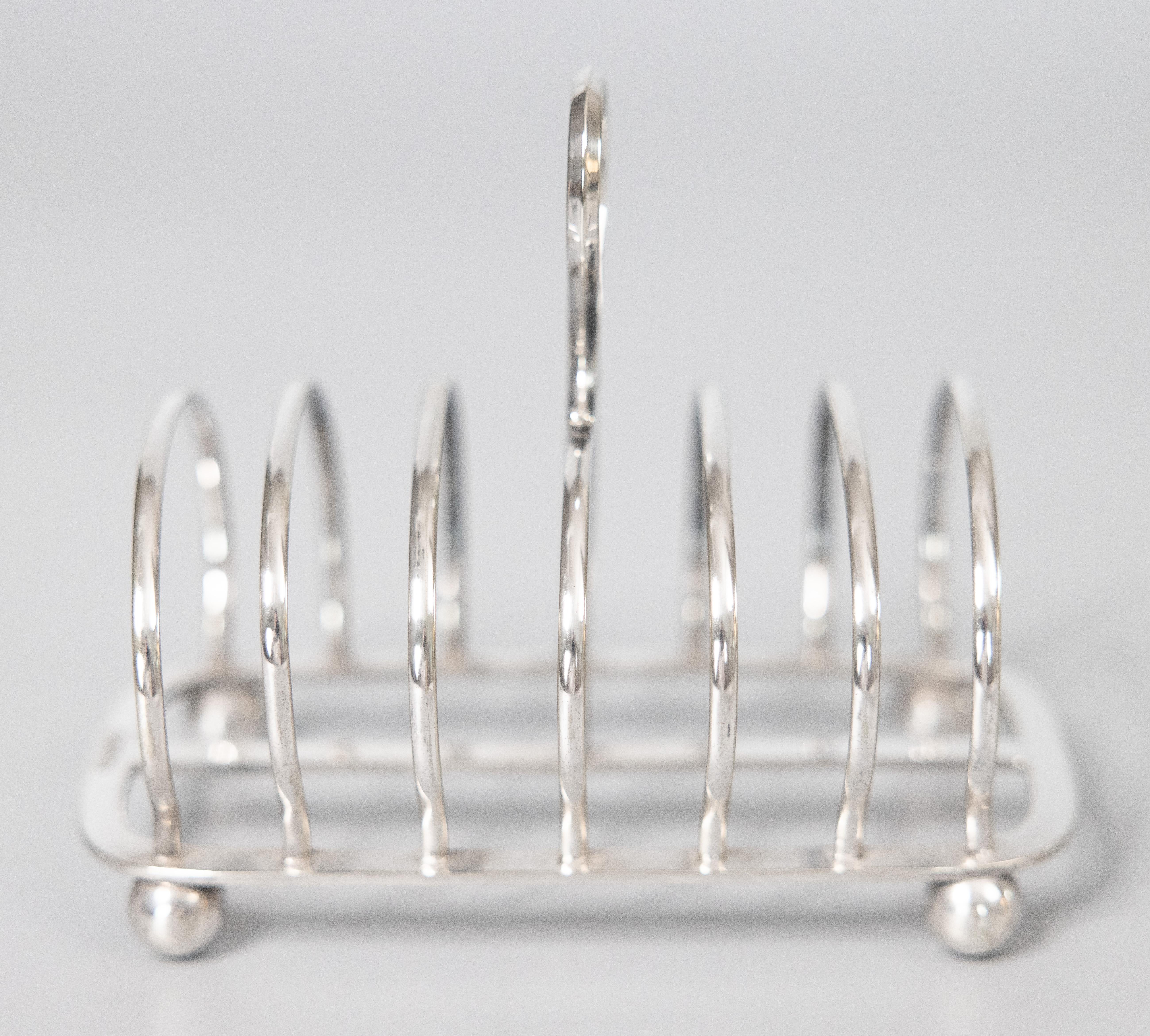 A stylish Art Deco English silverplated four slice toast rack. Hallmarks on base. This fine quality silver toast rack is well made and heavy with a lovely Art Deco style geometric shape, decorative finial, and charming ball feet. It would be