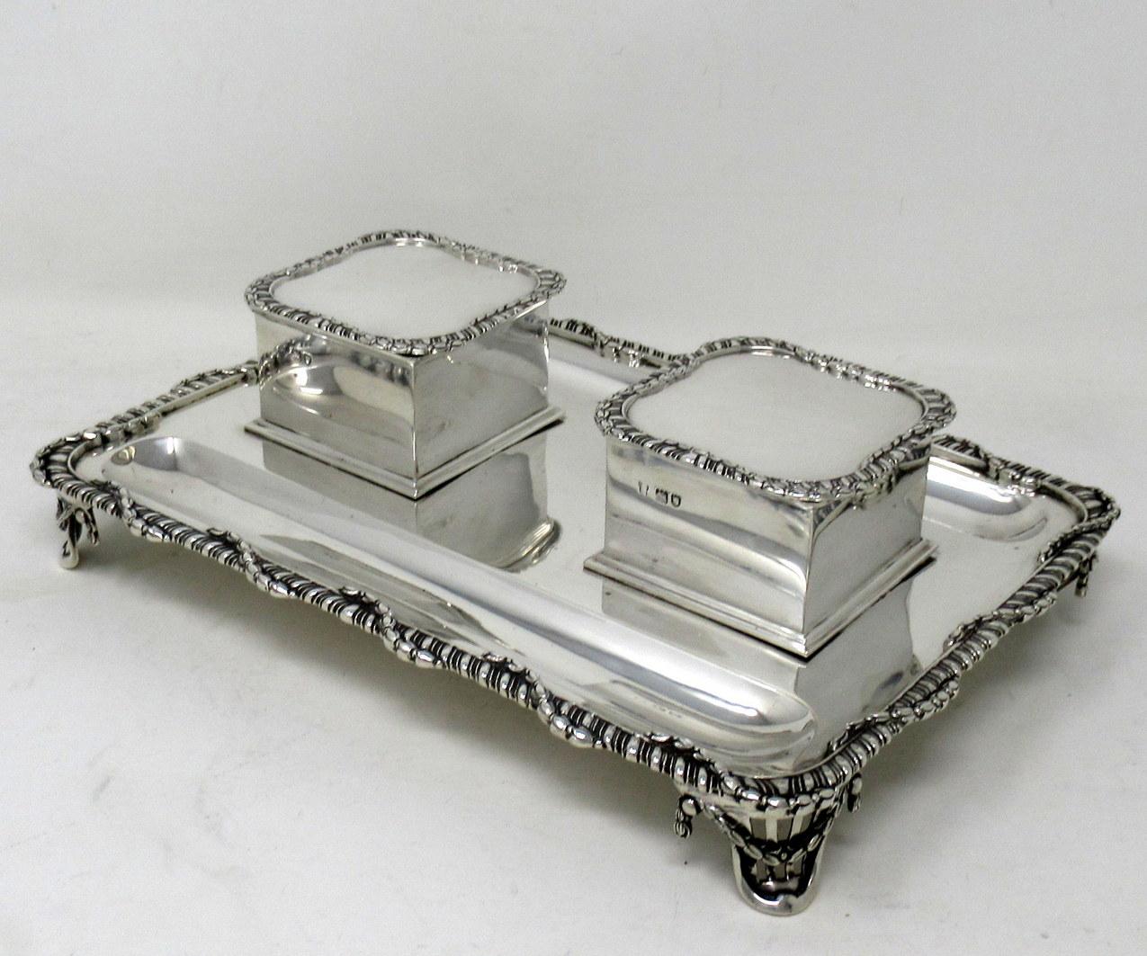 A Superb Example of an English Sterling Silver Art Deco Period Embossed twin ink bottle desk standish, complete with all its accessories to include a pair of removable silver mounted glass ink jars encased within their hinged lidded cases. 

The