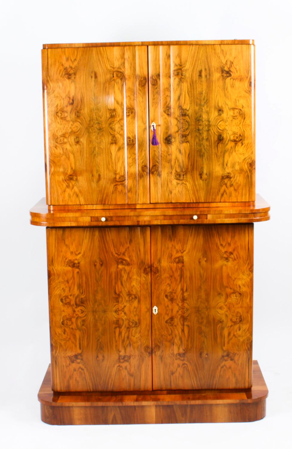 This is a fantastic antique Art Deco burr walnut cocktail cabinet, attributed to Epstein, with cut glasses and decanters, circa 1920 in date. 
 
There is no mistaking the timeless appeal of this highly collectable item and it would be a wonderful