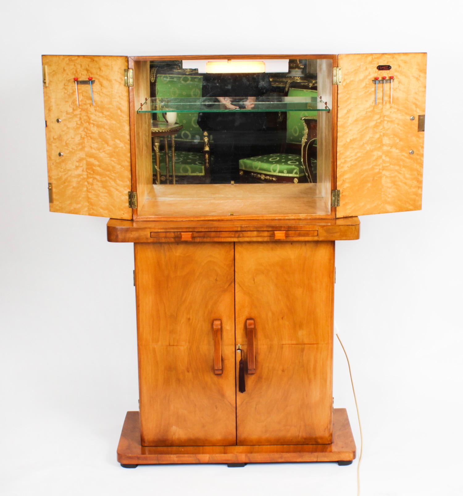 Il s'agit d'un fantastique cabinet de cocktail antique Art Déco en petite ronce de noyer, de la manière d'Epstein, par Turnidge de Londres, datant d'environ 1920. 
 
L'attrait intemporel de cet objet de collection est indéniable et il complétera à