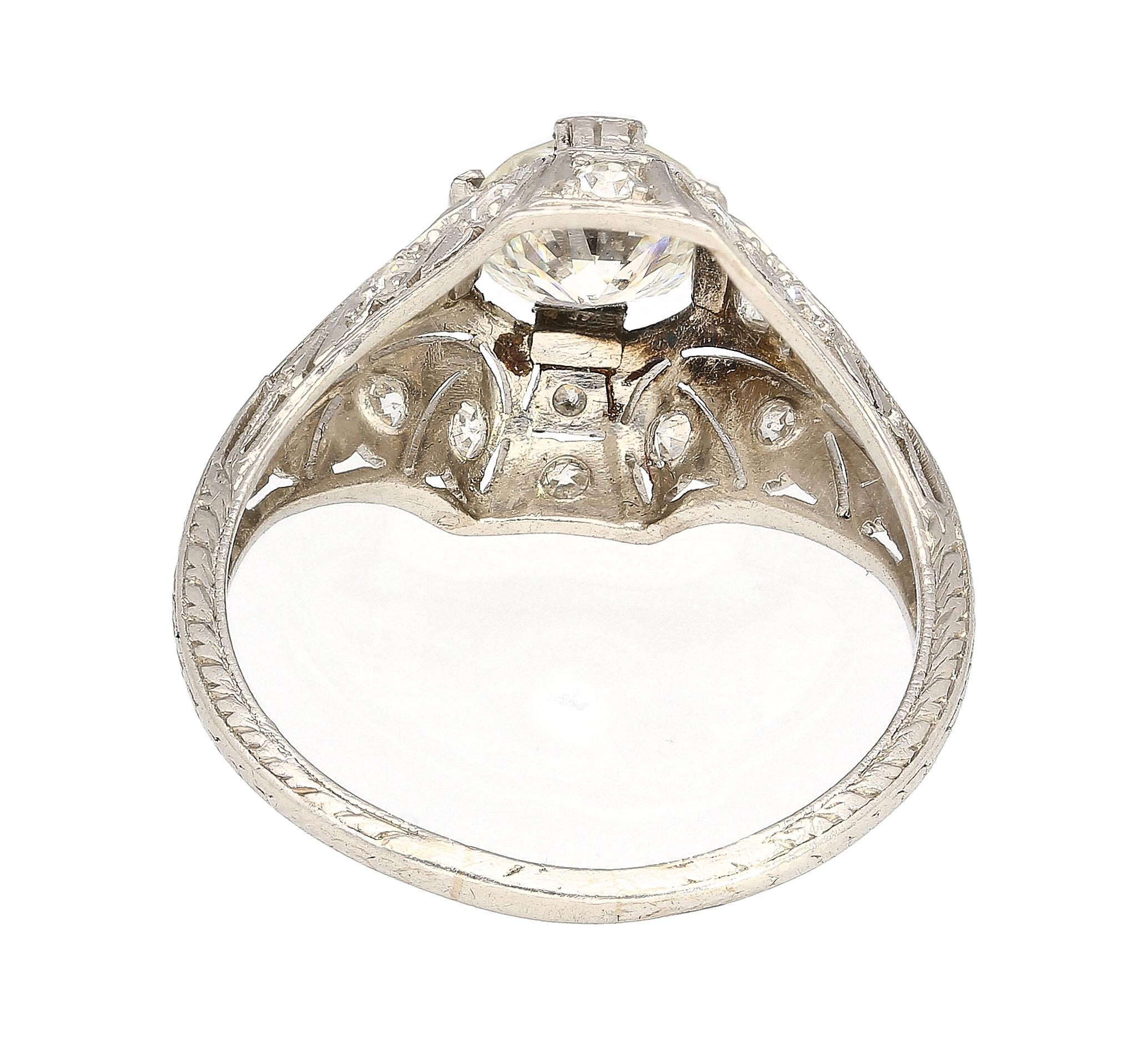 Immerse yourself in history with this antique Art Deco diamond ring. Set in platinum 900 with a curved filigree shank. Old European cut diamond center stone with superb brilliance and shine. Paired with 0.30 carats total in round cut diamond side