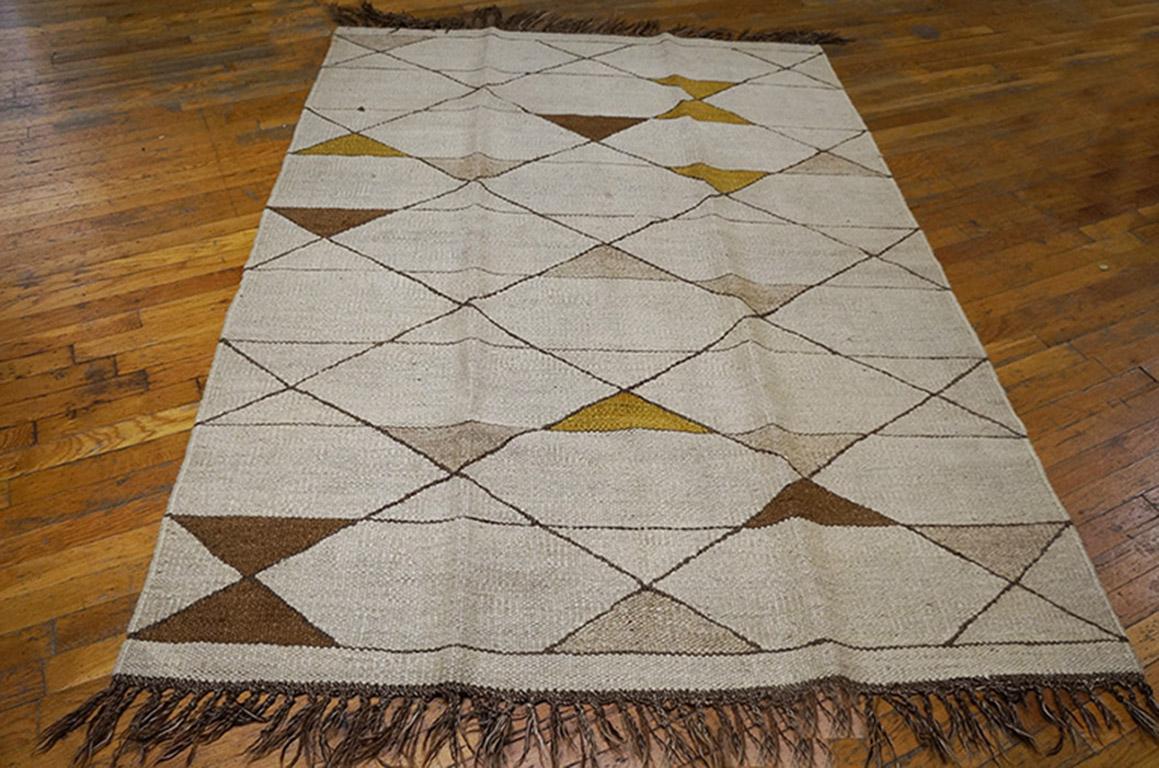 A little sister rug to our room-size carpet with a slightly sharper tonality, but the same basic Minimalist pattern of parallel horizontal and diagonal lines creating triangles accented in rust and red, and open plain hexagonal reserves on the sand