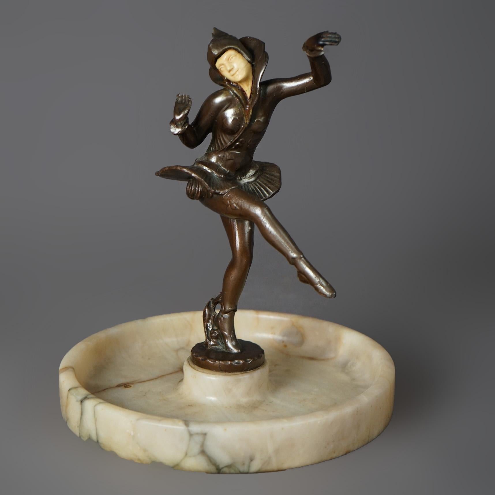 An antique Art Deco figural centerpiece offers figural cast metal sculpture of a dancing female harlequin with celluloid face over alabaster tray, c1930

Measures - 9