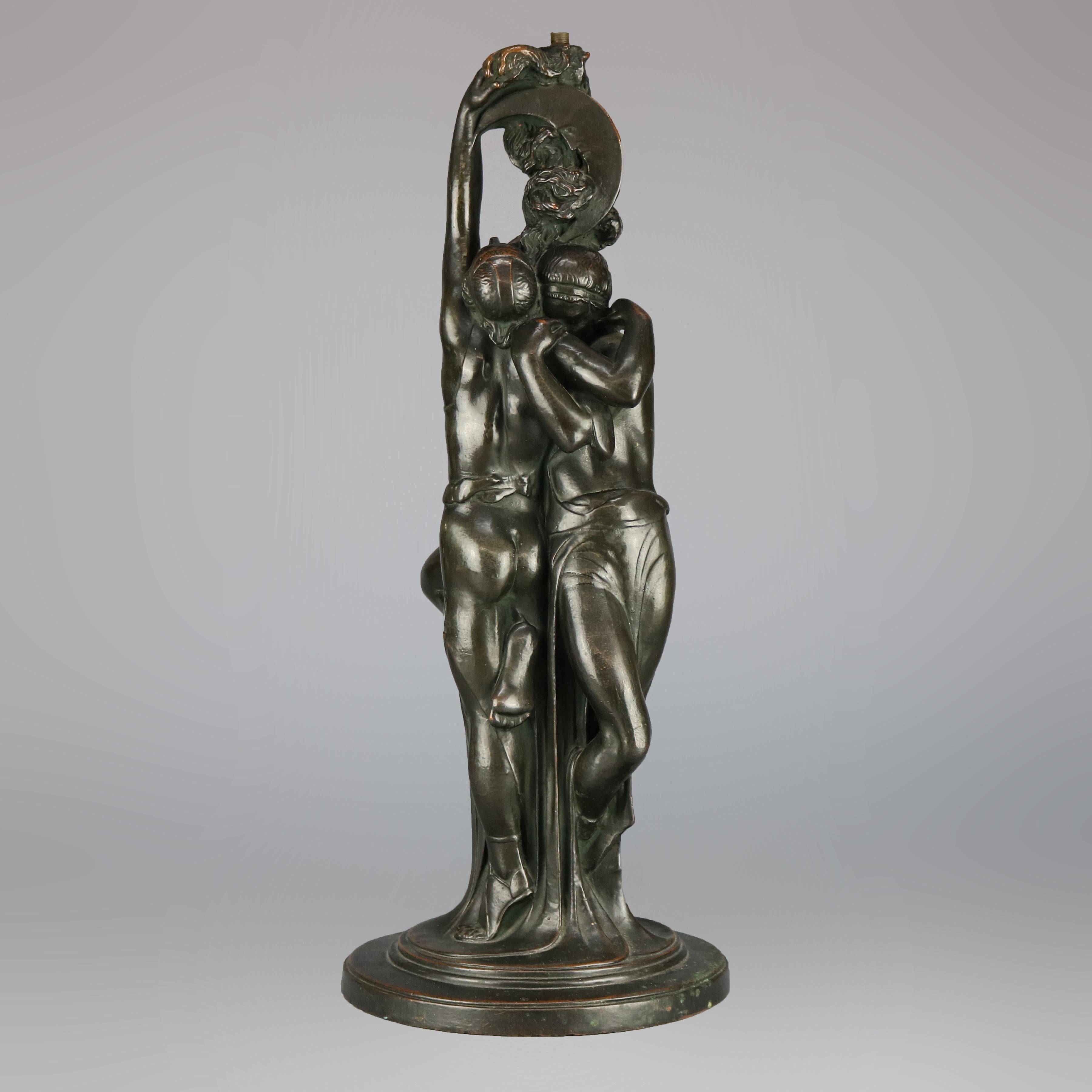 An antique Art Deco figural Paul Herzel sculptural lamp base offers bronzed clad cast construction and depicts two embraced lovers under the moon with an owl at foot, signed stamped 