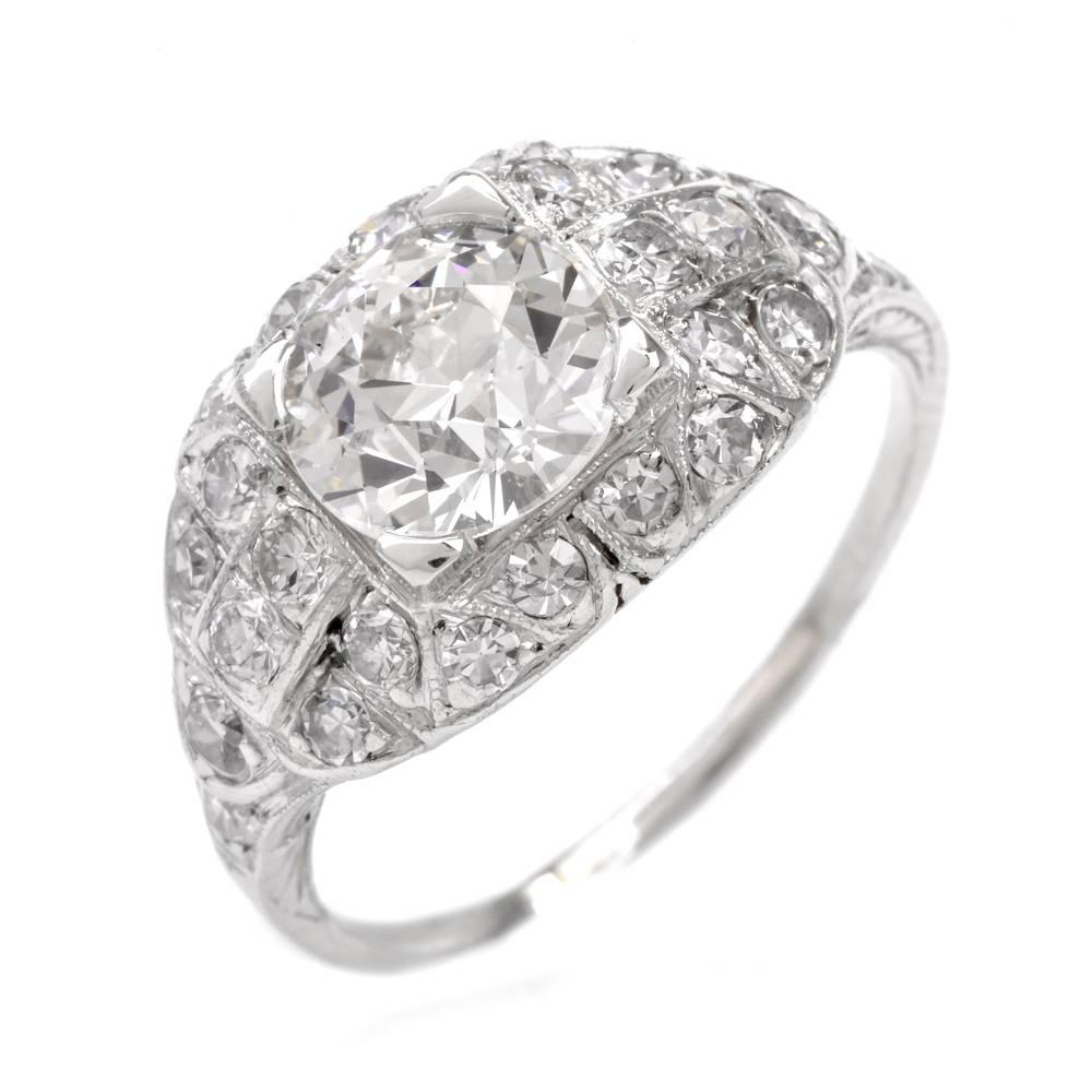 This alluring antique filigree engagement ring with openwork floral motif profiles throughout the subtly domed plaque is constructed in platinum, weighing approx. 3.9 grams and measures 10mm wide and 6 mm high.  The centrally positioned round