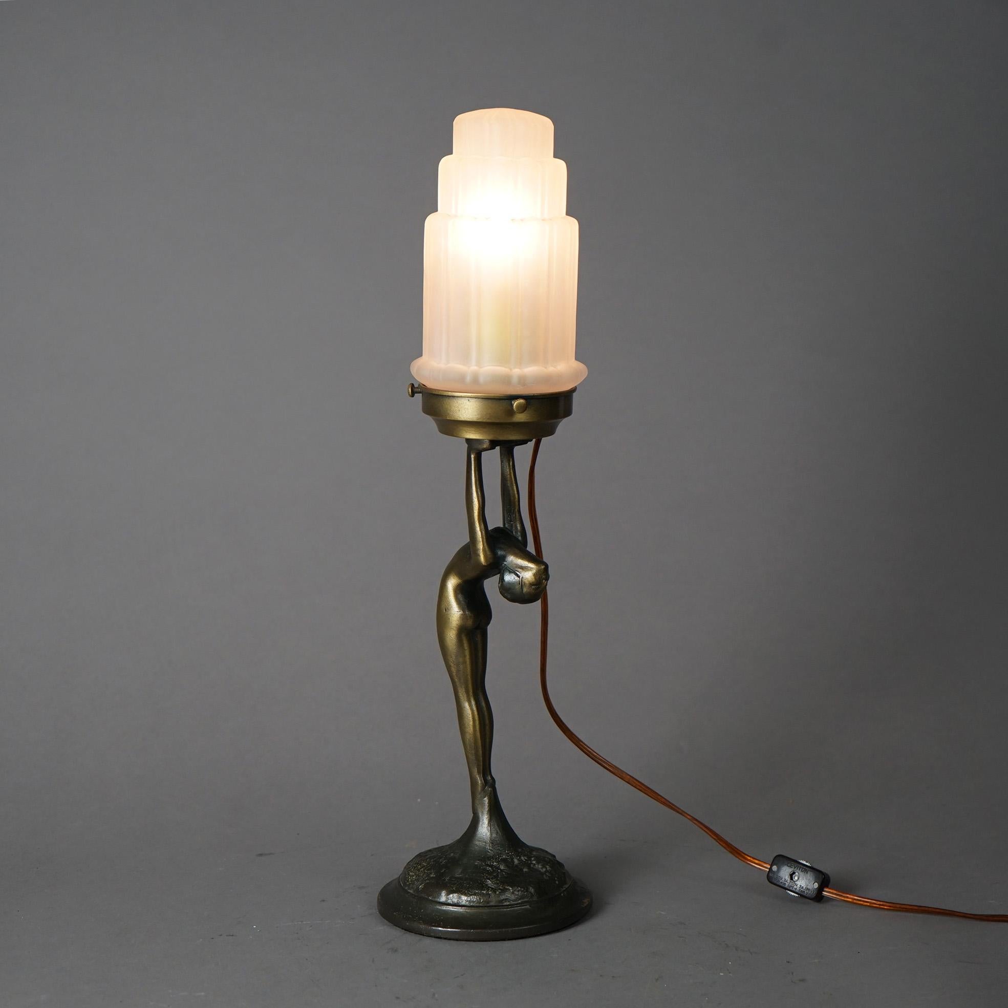 An antique Art Deco sculptural table lamp in the manner of Frankart offers cast metal base with standing figural nude of a woman raising an architectural form globe, early 20th century

Measures - 18
