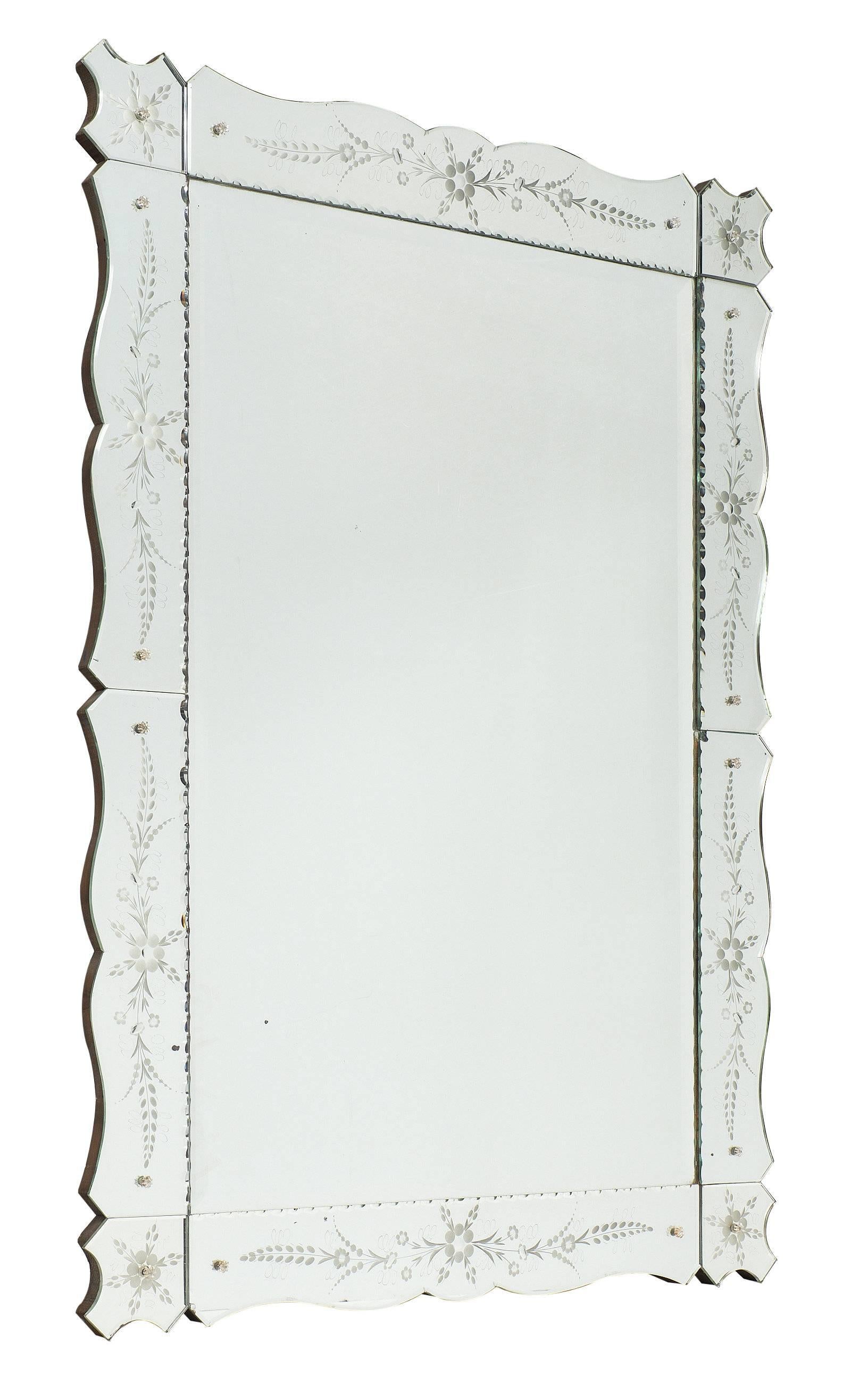 An Art Deco French mirror from the Art Deco period in a rectangular shape. The frame is made of mirror as well, with finely engraved floral details. The frame is also scalloped. This piece is in excellent antique condition.
