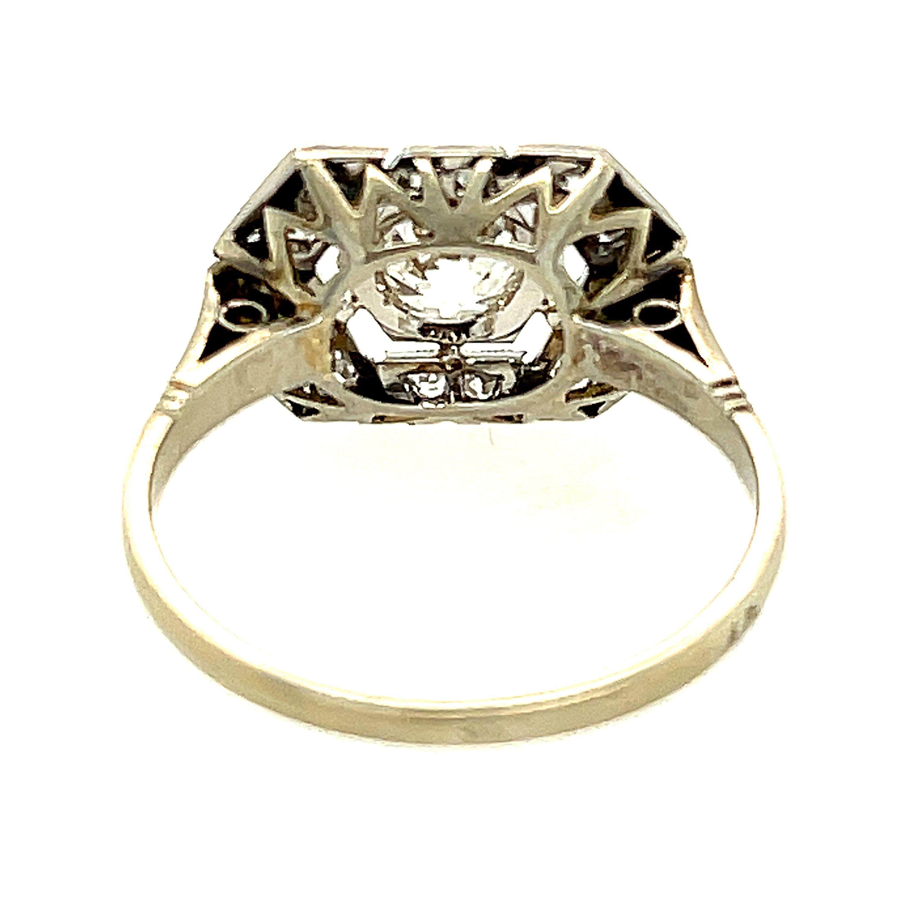 An attractive French platinum Art Deco diamond ring centering upon an Old European cut diamond weighing approximately 0.55 carats. The panel ring is set with 18 single cut diamonds weighing about 0.25 carats total. The center diamond is a nice white