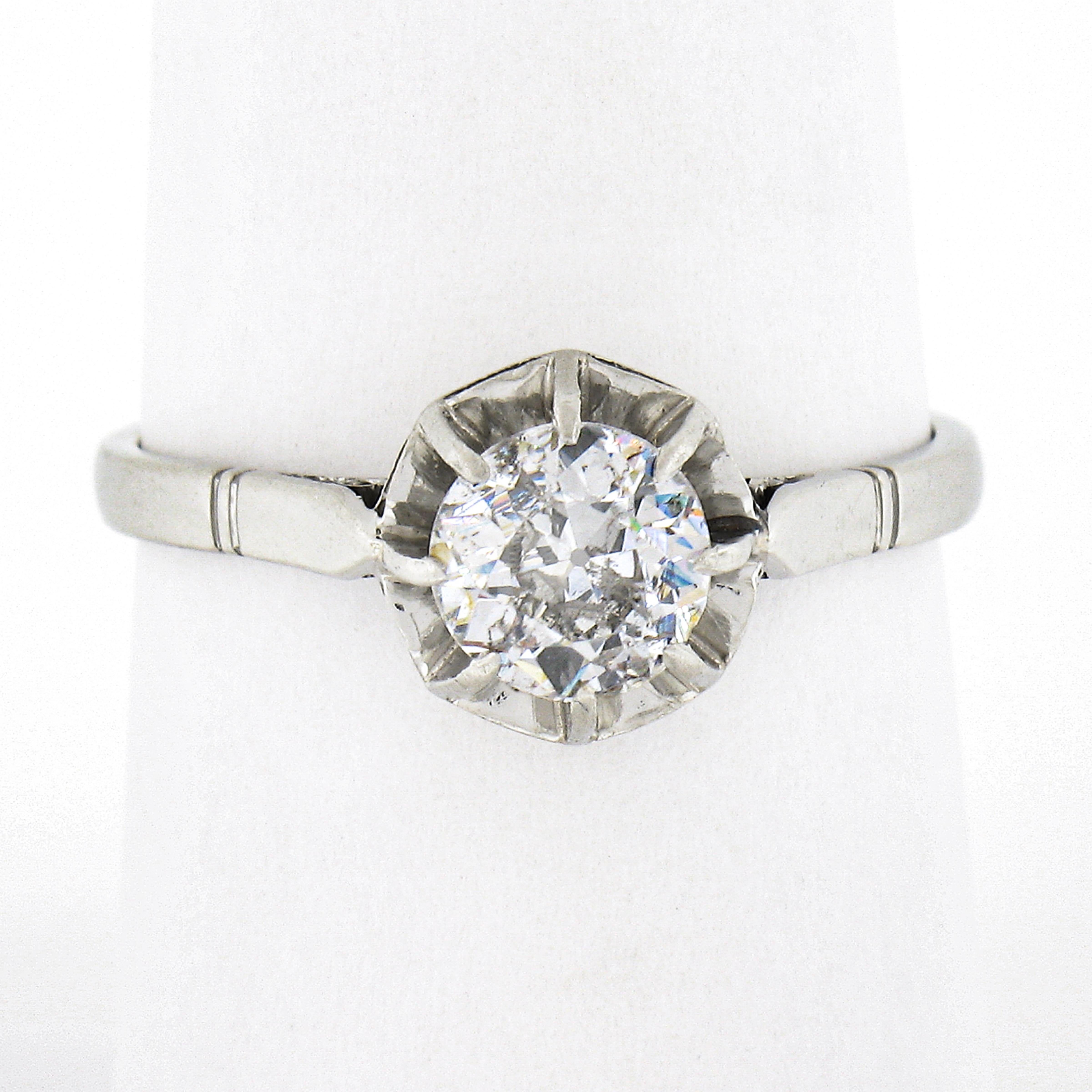 This gorgeous antique engagement ring was crafted in France from solid platinum during the art deco period and carries a stunning and super fiery old European cut diamond solitaire at its center. This fine quality diamond weighs approximately 0.80