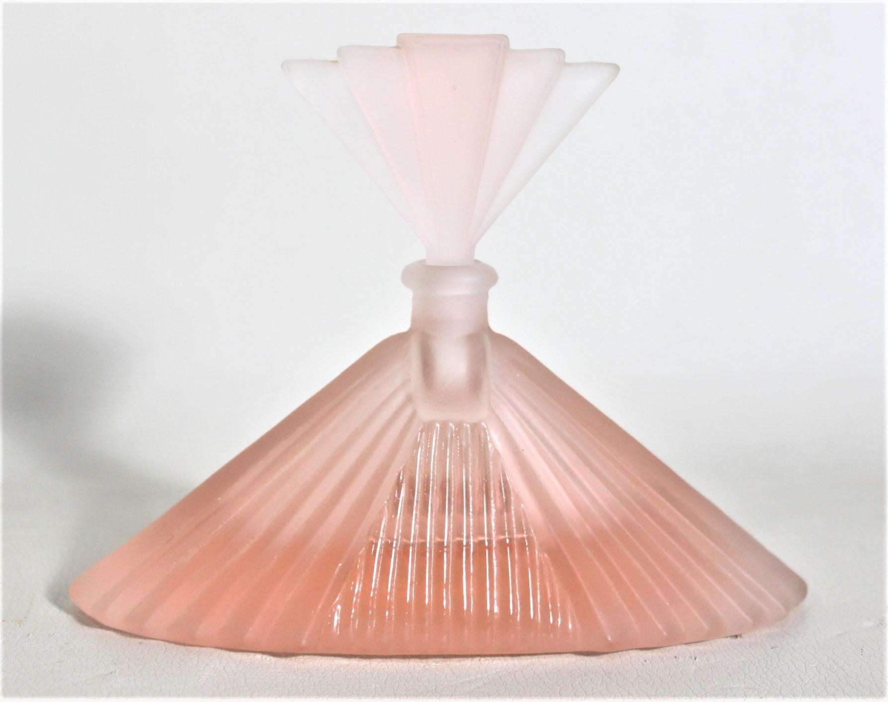 This Art Deco frosted pink perfume or scent bottle is unsigned, but presumed to have been made in France in approximately 1920 in the period style. The bottle is done in a frosted pale pink glass with a stopper in graduated pink tones. The base is