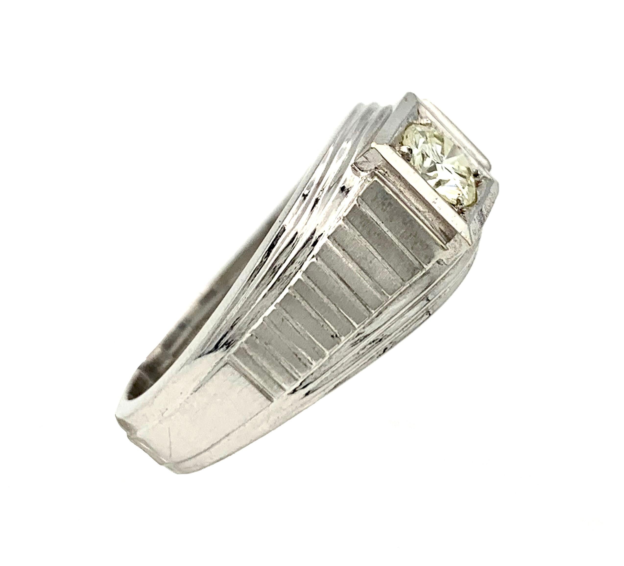 The square ring head holds a round brilliant cut diamond. The ring shoulders show a geometric design.
The ring is cast out of 14 karat white gold marked 585  on the inside of the ring band . 
