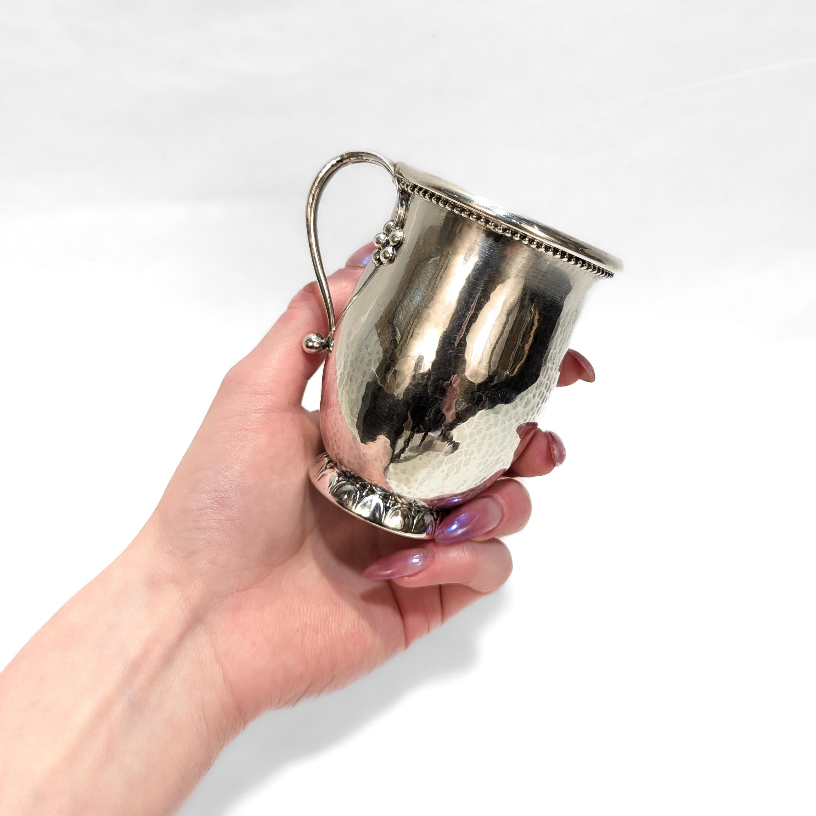 A fine Danish Modern handled cup.

In sterling silver.

By Georg Jensen.

Pattern no. 427A

With a hand-hammered body, bead and flower devices, and a split handle

Fully marked to the base.

Simply a wonderful antique Jensen silver cup!

Date:
Early