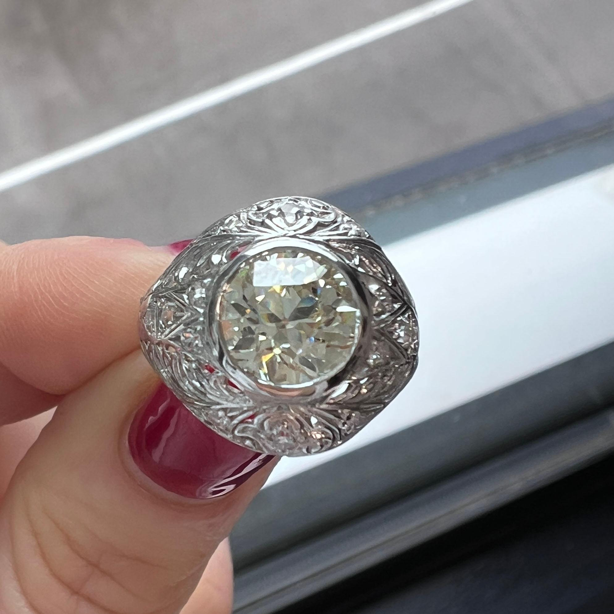 This antique Art Deco diamond engagement ring is a true masterpiece, showcasing exquisite craftsmanship and timeless elegance. At its heart lies a stunning GIA-certified 1.71-carat old circular brilliant-cut diamond, graded N color and VS1 clarity,