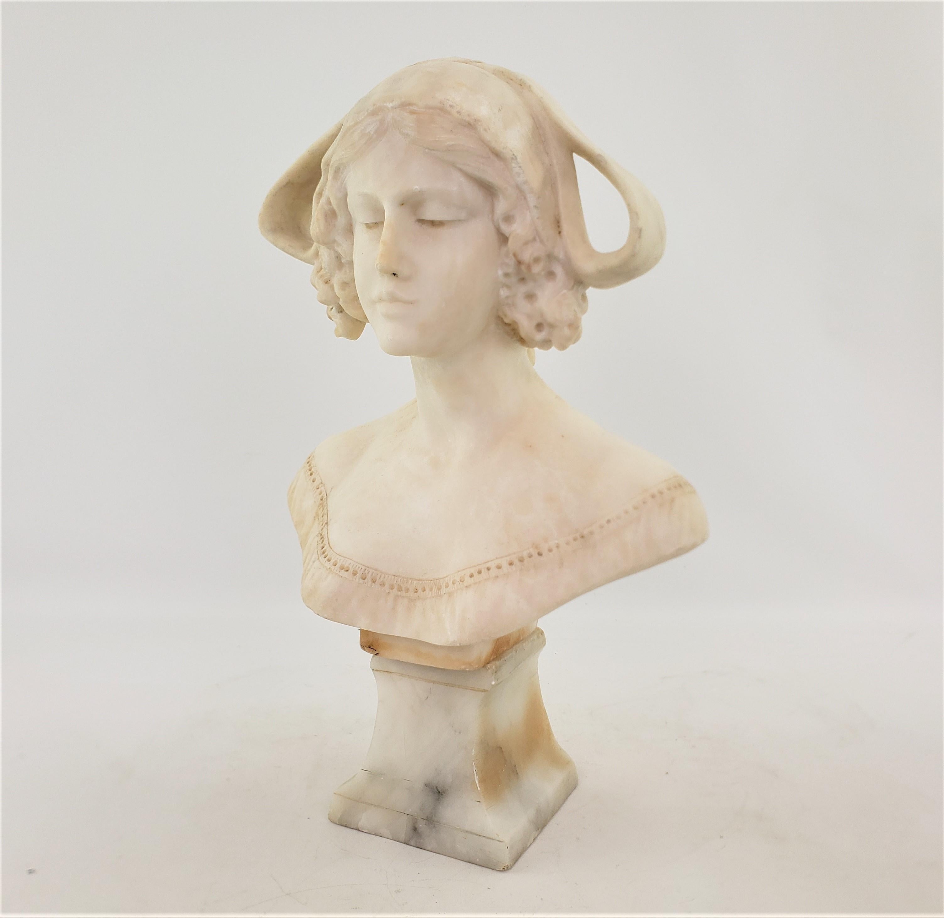 This antique bust or figurative sculpture is unsigned by the artist, but is identified as originating from Italy and dates to approximately 1920 and done in the period Art Deco style. The bust and base are composed of solid hand-carved alabaster and