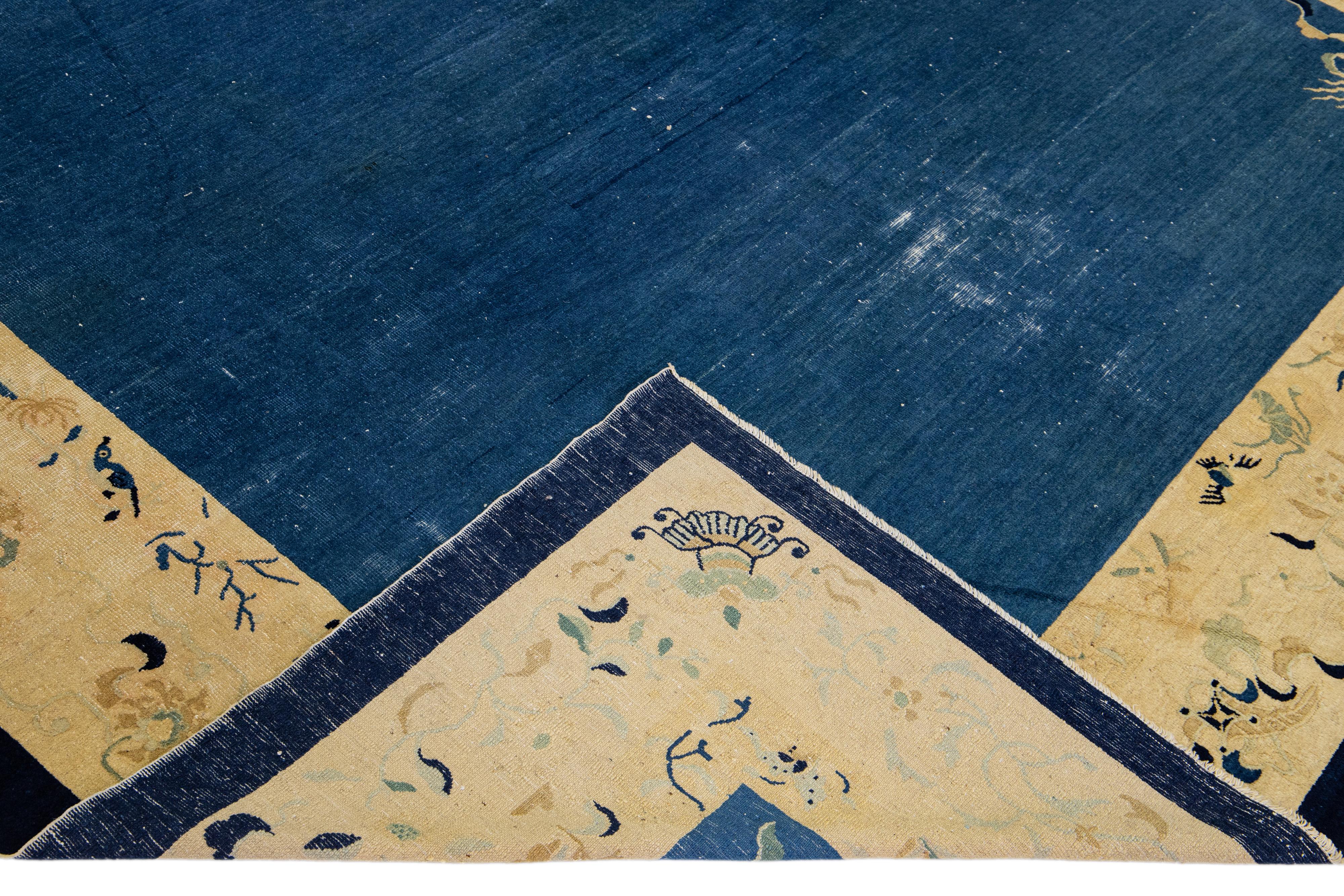 Beautiful antique Art Deco hand-knotted wool rug with a blue field. This Chinese rug has a tan frame in a gorgeous all-over Chinese floral design. 

This rug measures: 9'1