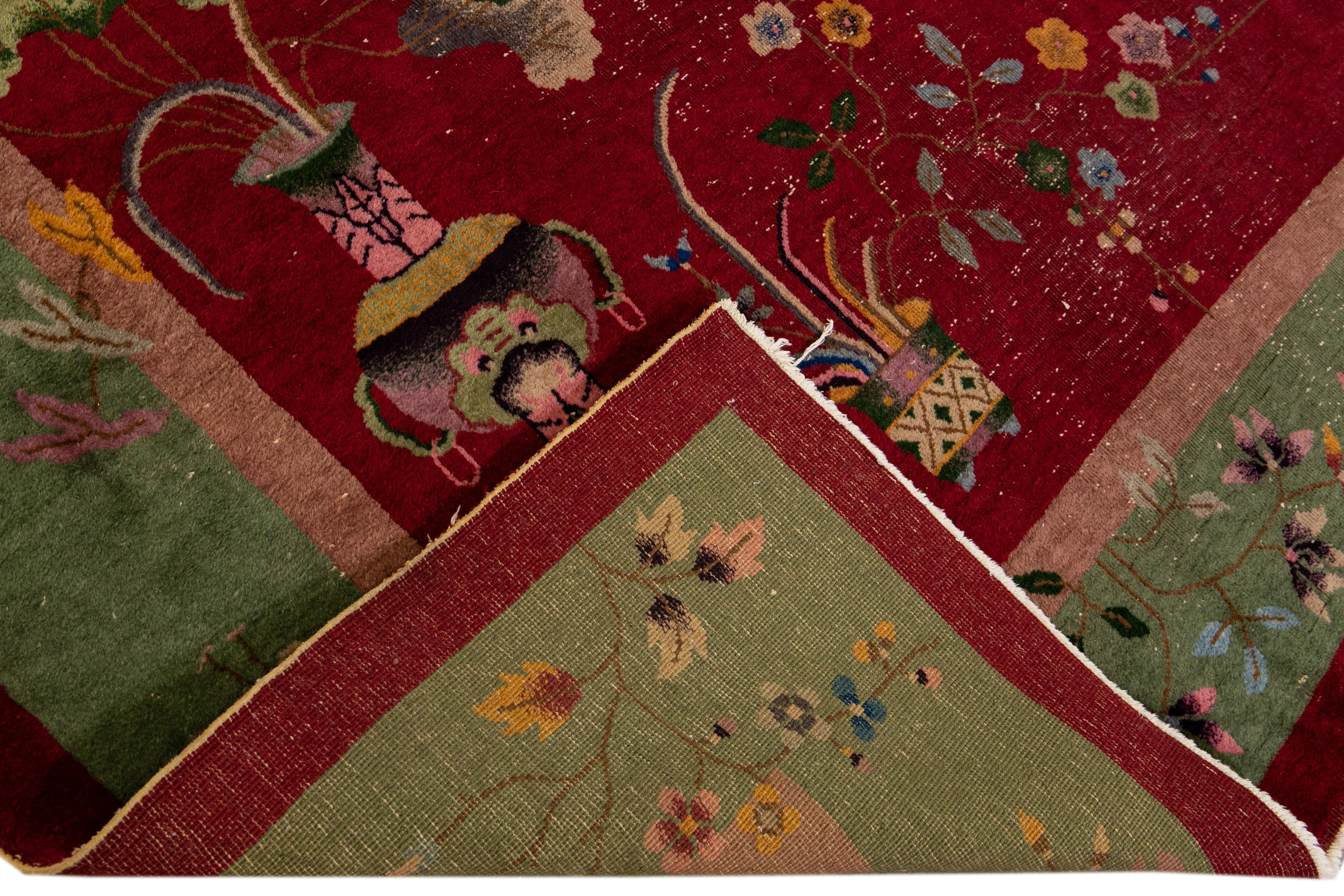 Beautiful antique Art Deco Chinese hand-knotted wool rug with a red field. This Chinese rug has a green frame multi-color accents in a gorgeous all-over traditional Chinese floral design. 

This rug measures: 9' x 11'8