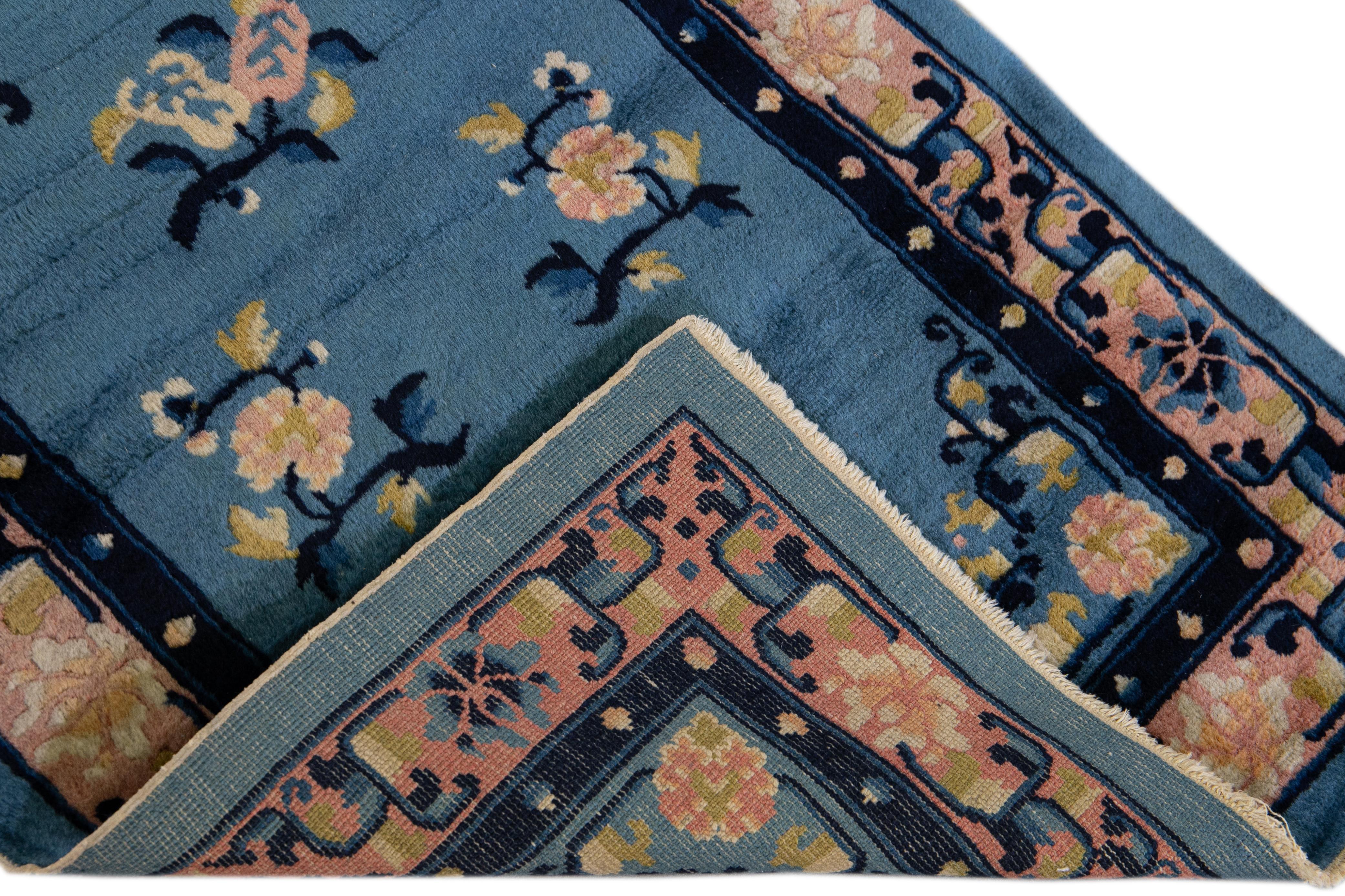 Beautiful antique Art Deco Chinese hand-knotted wool rug with a blue field. This Chinese rug has a peach frame and ivory and goldenrod accents layout in a gorgeous Chinese floral design. 

This rug measures: 2'4