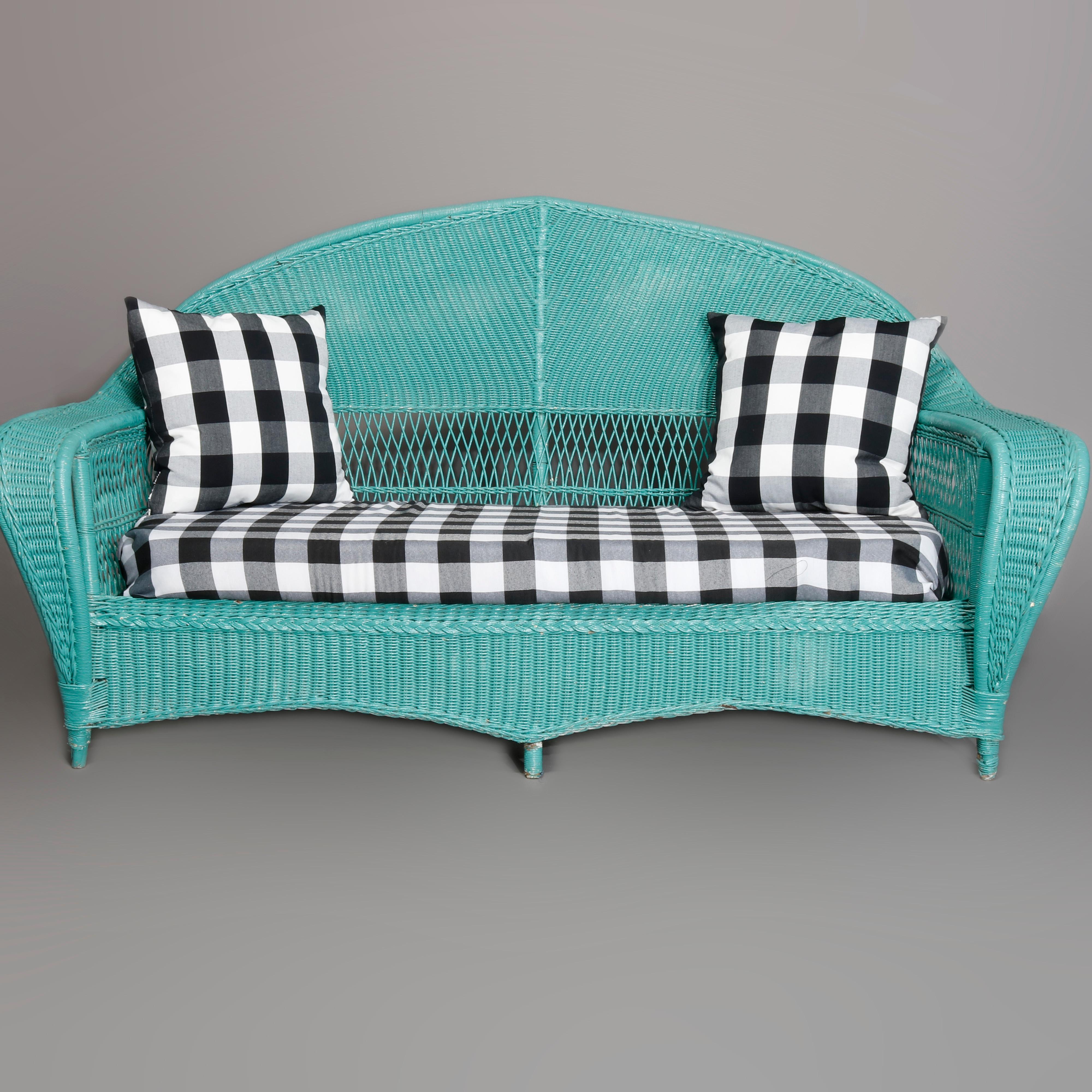 Antique Art Deco seating set by Heywood Wakefield offers turquoise blue painted wicker construction with arched backs and oversized waterfall form arms, having black and white checked upholstered seats, 20th century.

Measures: Settee- 39